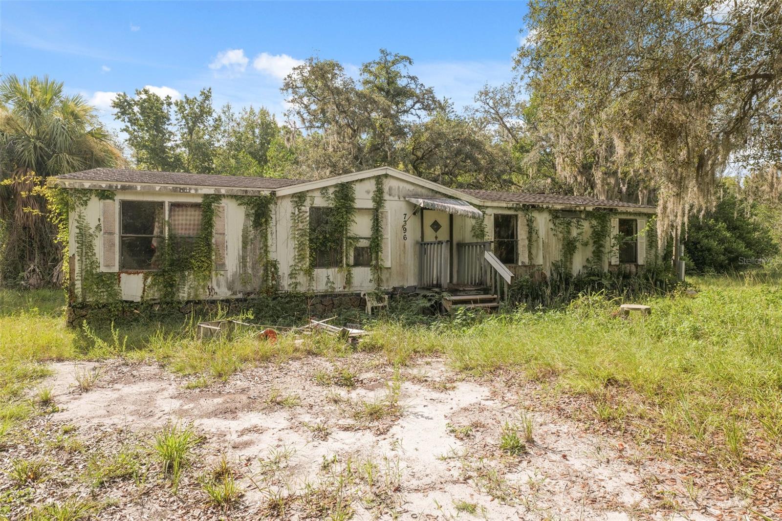 Situated on a spacious corner lot just over one acre, this unique property is rich with possibility and surrounded by mature trees and natural Florida landscape, offering a peaceful and private setting that invites your imagination to take root. With water and electric already in place, you're one step closer to building your dream home—whether that means removing the existing structure and starting fresh or shaping the land to fit your vision. The wooded backdrop adds character and seclusion, while the generous lot size gives room to create outdoor spaces that feel like a true escape. Imagine mornings on a wraparound porch shaded by oak trees, gardens that stretch wide beneath the sun, and evenings spent under star-filled skies. Located just 5.5 miles from the Suncoast Expressway, commuting to Tampa or nearby cities is convenient and quick—making it ideal for those who crave both quiet living and urban accessibility. Nearby attractions include Weeki Wachee Springs State Park (5.4 miles), famous for its crystal-clear river and kayaking adventures; Pine Island Beach (11.2 miles), a perfect spot to unwind by the Gulf; and the Nature Coast Botanical Gardens (2.1 miles), a peaceful escape filled with vibrant blooms and walking paths. This property offers more than just land—it offers the promise of home.