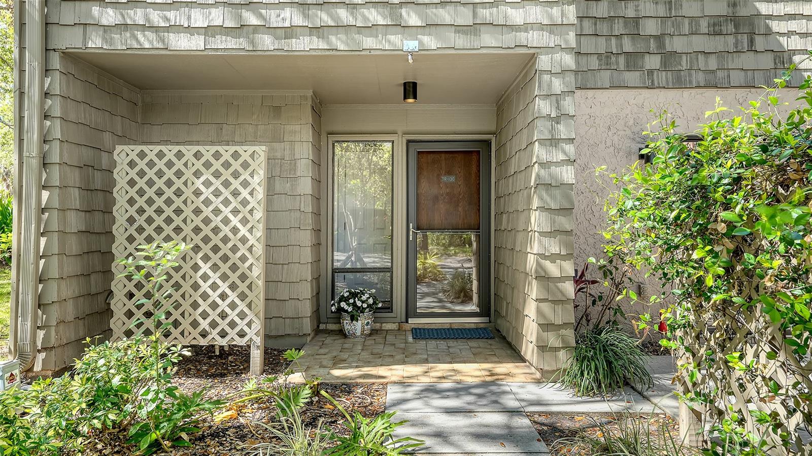Blending into the natural setting of the gardens and trees within Pelican Cove in Sarasota, this lovely three-bedroom and three-bath home has been stylishly renovated and designed for relaxed Florida living. As an end unit with an abundance of windows, light streams into the condominium and sliding doors open up to a private fenced outdoor patio in the front and also to an open back patio, bringing the outside in. The downstairs interior living space of the two-story condominium was enhanced by raising the former lanai and combining it into the open living area of the family room and kitchen, adding to the seamless flow between all rooms. The impressive vaulted ceiling in the large living room adds to the exceptionally spacious, bright and breezy feel of the home. Upstairs and down, designer touches and accents are found everywhere. All three baths have been totally updated with wood vanities, granite countertops and full glass shower and bath remodeling, upgraded interior doors and hardware were installed in every room, crown molding was skillfully built around ceilings, and all doors and windows reframed with classic wood molding. On the first floor, a major renovation was completed. The kitchen was opened up to the family room and beautifully remodeled with KraftMaid quality cabinets, granite countertops, stainless appliances and undercounter lighting, while the popcorn ceilings were removed and then replaced, and recessed lighting added. The entire downstairs flooring was replaced with neutral-colored large ceramic tiles throughout at that same time, designer drapes installed and, most recently in 2023, all walls and woodwork were freshly painted and one of two air-conditioning systems replaced in 2024. The second floor is accessed by an architecturally pleasing stairway, with a landing overlooking the living room and leading to a comfortable layout of the bedrooms upstairs. The two guest rooms have large windows with Hunter Douglas blinds, ample wall closets and they share a bath. The private primary bedroom suite is conveniently separated from guests, with a walk-in closet with built-ins, the redone en-suite bath and, through a wall of sliders, a cozy balcony overlooking the backyard. The Pelican Cove community is somewhat hidden from the hubbub, but is centrally near lots of shopping, dining, beaches and all cultural events downtown Sarasota has to offer! There is something for everyone in this waterfront and pet-friendly place, aquatic sports in one of the six outdoor pools, tennis and pickleball, yoga, bird watching, exploring along the boardwalks some of its 78 acres, kayaking, taking classes at Pelican Cove University or joining one of 37 clubs offered. There is also an 86-slip boat harbor for boating enthusiasts with low-cost rates, call HOA for availability. This condominium and its community are special so call for a private showing.