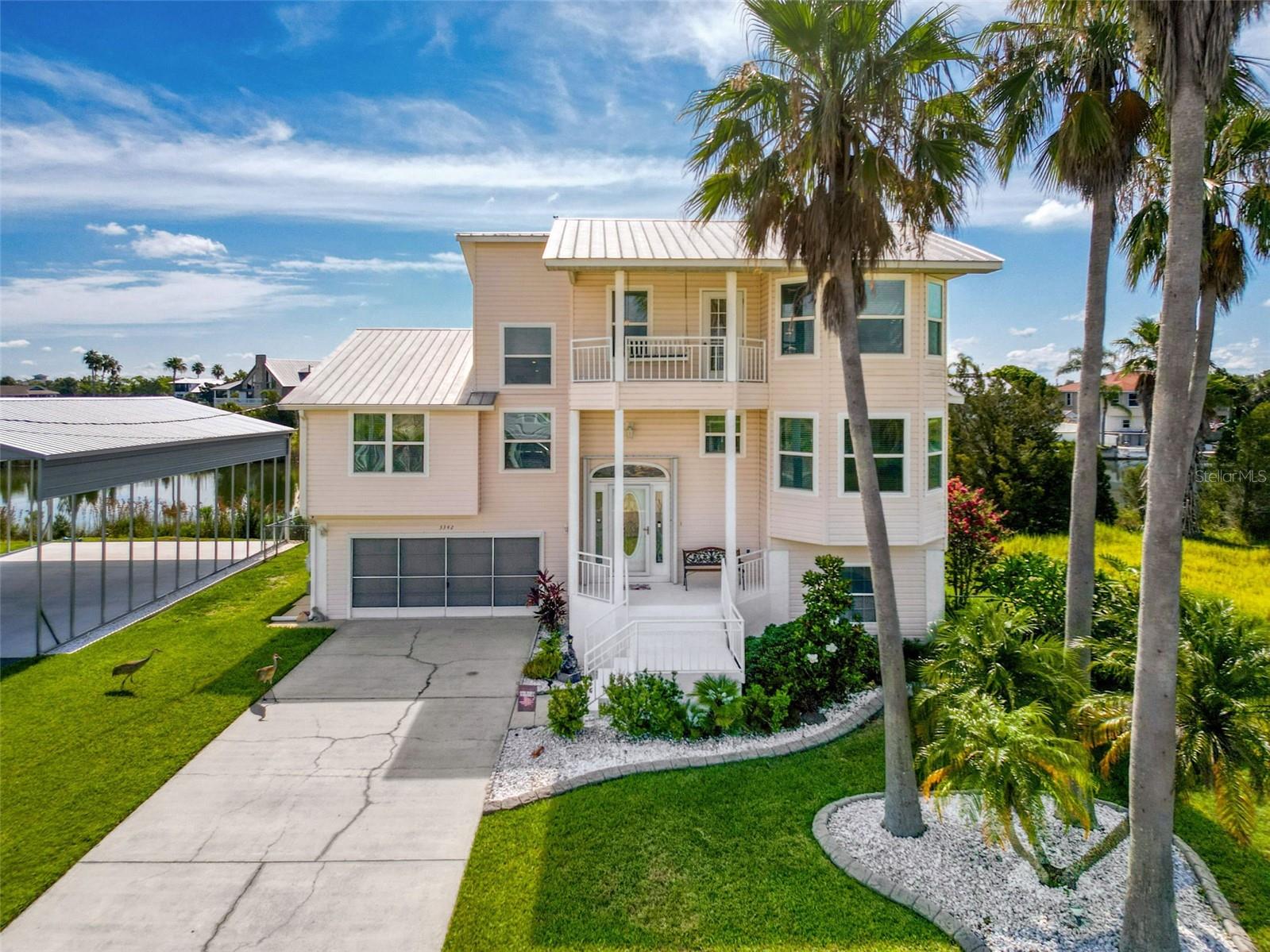 Welcome to your waterfront retreat in Hernando Beach! This maticulously maintained 3-bedroom, 2-bath home is packed with upgrades and sits on a rare double lot totaling 1/3 acre. Bring your Boats and RV — the brand-new spacious 30'x45' reinforced RV/Boat port (2024) is ready for all your toys! A true highlight of the property is the nearly 2,000 square feet of basement/garage space — spacious enough to fit four vehicles plus recreational toys, and still have plenty of room for a large workshop. It even includes a convenient half bath for added flexibility. Inside, you'll find a bright and inviting interior with an open living area, vaulted ceilings, remodeled kitchen and bathrooms, custom 5 inch baseboards, wood valances and new laminate. In the bathrooms, tile showers, guartz countertops, and new vanities and sinks. The kitchen features quartz, a walk-in pantry, undermount lighting, stainless steel appliances and a breakfast bar. Enjoy peace of mind with a metal roof upgraded and reinforced in 2022, 2022 HVAC, 2022 irrigation system, and a 2021 hot water heater. Additional upgrades include Anderson triple-pane impact storm windows (2013), a hidden safe, a security system, and full-house generator wiring (Generac XT8000E generator negotiable). Outdoor spaces are designed for relaxation, with a screened lanai overlooking the canal, dock, a third story porch swing perfect for sunset views, and a fenced yard with room to roam. The versatile loft upstairs offers great flexibility — use it as an office, guest room, or enclose it for a 4th bedroom. With space, style, storage, and waterfront living, this move-in-ready gem with a direct panoramic view of the Gulf is the total package!