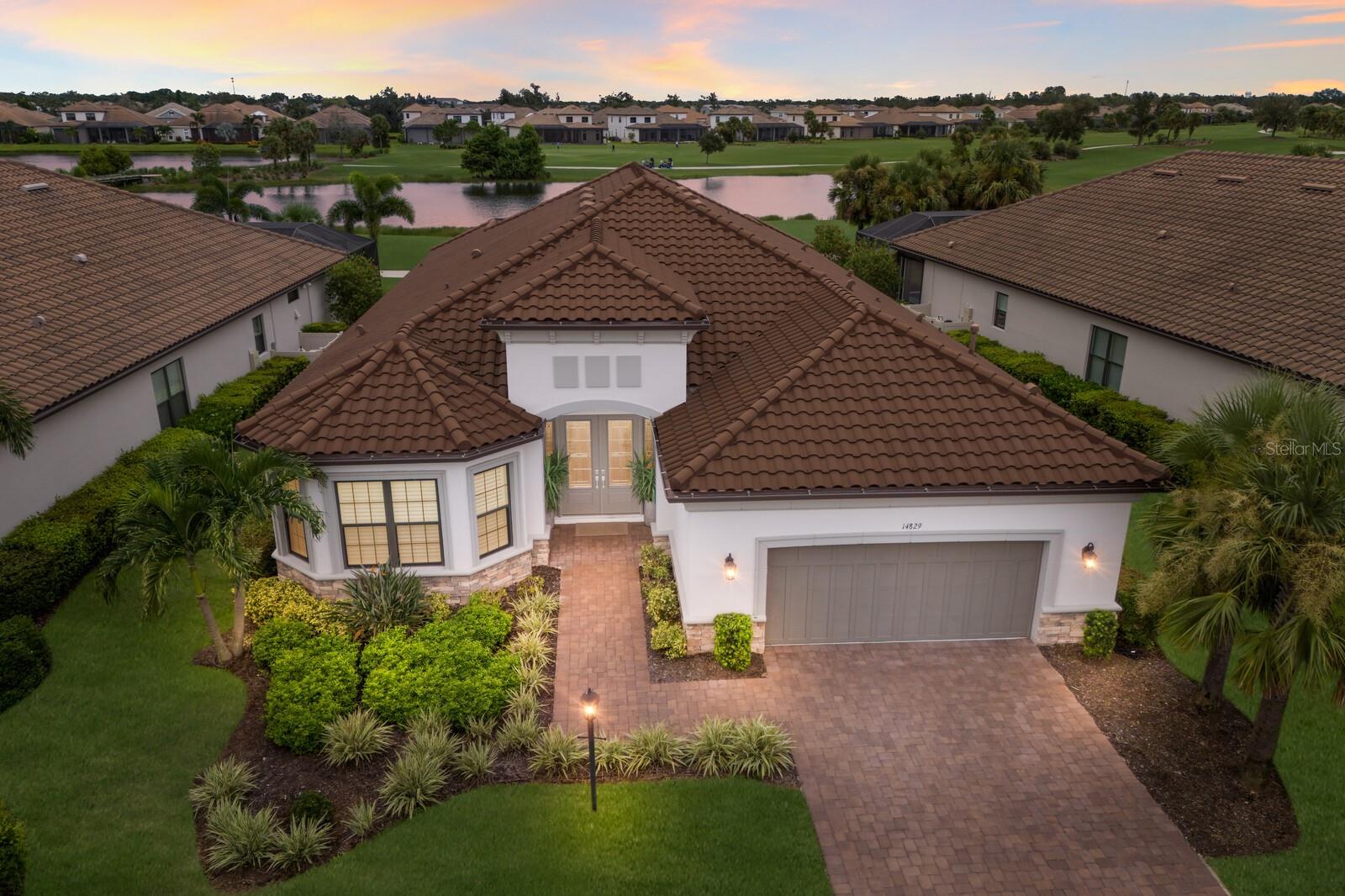 LUXURY living at its finest in the highly sought after 18-hole CHAMPIONSHIP GOLF community of Esplanade at Azario in Lakewood Ranch, where this STUNNING 3 bedroom plus den, 3 bath, 2 car garage Pallazio Model by Taylor Morrison offers a true entertainer’s dream. From the moment you step through the ELEGANT double doors into the foyer adorned with a multi layer tray ceiling, crown molding, chandelier, custom tiled wall and wood columns, you are greeted with an open-concept floor plan that flows seamlessly through the kitchen, dining, and living areas. The CHEF'S kitchen features a large island with seating, stone countertops, a STYLISH backsplash, stainless steel appliances including a built-in oven, microwave, and gas cooktop with hood, along with CHIC glass pendant lighting. The spacious living room showcases a CUSTOM STONE feature wall with electric fireplace and an elegant tray ceiling with MODERN lighting, while a full wall of sliders leads out to the lanai. The dining area is elevated with a CUSTOM WOOD trim mirrored accent wall, creating the perfect space for elegant dinners. The oversized primary suite offers multiple windows overlooking the pool, a spa inspired ENSUITE BATH with dual sinks, vanity, a large walk-in tiled shower, and walk-in closet, creating the ultimate retreat. Two additional bedrooms with full baths provide comfort for guests, while the glass French door DEN with custom built-ins is ideal for a home office. A well designed laundry room with abundant cabinetry adds convenience. LUXURY VINYL flooring runs throughout the main living areas and primary suite, adding both durability and elegance and a WHOLE HOME GENERATOR provides peace of mind. Step outside to your PRIVATE OASIS featuring a saltwater heated pool and spa with panoramic screen enclosure overlooking the golf course and pond, a travertine lanai, motorized privacy screens, LED-lit awning, and a fully equipped OUTDOOR KITCHEN with stainless steel grill, hood, refrigerator, ice maker, and ample cabinetry, making it perfect for entertaining and relaxing while taking in breathtaking SUNSETS. Designer upgrades abound throughout, including PLANTATION SHUTTERS, CUSTOM WINDOW TREATMENTS, PRIVACY BLINDS on sliders, high ceilings, custom tray ceilings, chandeliers, whole house gutters, all enhanced by beautifully landscaped grounds. Living in Esplanade at Azario means RESORT STYLE amenities at your fingertips, including a clubhouse, culinary center, golf shop, tennis, pickleball, bocce, wellness and fitness center, spa services, Bahama Bar restaurant, resort pool, and scenic walking trails. Lakewood Ranch is known for its A+ rated schools and is perfectly located just a short ride to downtown Sarasota, St. Pete, world-class shopping, fine dining, and the FAMOUS Gulf beaches. This one-of-a-kind home offers elegance, comfort, and the unmatched lifestyle of a year round vacation. Start living your Florida LIFESTYLE today!!