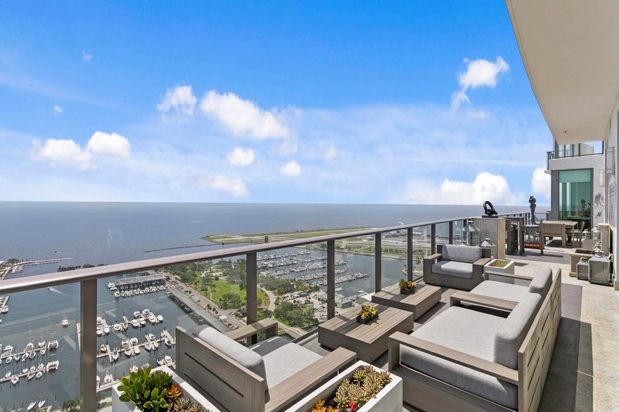 UNPARALLELED PENTHOUSE SANCTUARY | THE SKY COLLECTION AT THE ONE IN DOWNTOWN ST PETE | This is not merely a residence—it's a statement. Exclusively crafted by combining two premium units during the building’s construction, this extraordinary penthouse represents the pinnacle of luxury living in downtown St. Petersburg. Perched on the 39th floor, this one-of-a-kind sanctuary offers the most coveted panoramic views of Tampa Bay through floor-to-ceiling windows that frame the endless horizon. This residence lives like a single family home with 11’ ceilings and amenities that you would only typically find in a home.  Culinary Excellence Redefined  | The chef's kitchen stands as a masterpiece of form and function, featuring an oversized waterfall island with stunning 2.5-inch Sapienstone countertops that flow seamlessly into a matching backsplash. Exquisite imported NAC-crafted cabinetry provides both beauty and superior functionality throughout. Every detail has been meticulously considered: Jenn-Air double panel refrigerators, a Jenn-Air Euro Style Series double oven, a premium Rohl sink, and a full butler's 2nd kitchen that can be completely hidden from the main living area which also has its own private entrance for easy catering and deliveries. The sophisticated bean-to-cup Miele coffee machine and built-in Miele wine refrigerator positioned perfectly off the dining area ensure effortless entertaining at the highest level.  Master Suite Wellness Sanctuary Retreat | Take in your private haven featuring soaring high ceilings and an oversized master closet with custom cabinetry expertly crafted by California Closets and NAC, creating a sophisticated storage solution that rivals the world's finest boutiques. The spa-inspired master bath becomes your personal age-rejuvenation center with dual vanities featuring premium Grohe fixturing, a luxurious soaking tub, and an oversized shower complete with a Steamist steam system and a unique built-in cold plunge tub. This extraordinary combination of therapeutic heat and invigorating cold therapy offers the ultimate in wellness and anti-aging benefits, creating your private longevity sanctuary. The Kohler smart toilet reflects the attention to innovative luxury throughout.  Unmatched Privacy & Outdoor Living  | As the building's only recessed unit, this penthouse provides an unparalleled sense of privacy and exclusivity. Rollease Acmeda motorized shades with remote controls offer effortless light control while maintaining those stunning vistas. The expansive 600-square-foot wrap-around terrace—the largest in the entire building—becomes your private sky deck, complete with curated designer furnishings and an elegant fountain, creating an outdoor oasis suspended above the city.  Sophisticated Living Spaces | Every room showcases globally-sourced designer furniture, finishes, fixtures, including 3 stunning Murano chandeliers. A premium Sonos sound system provides seamless audio throughout, while four Samsung Frame TVs blend technology with aesthetics. Refined Guest Accommodations | Guest bathrooms showcase elegant marble flooring and feature Villeroy & Boch commodes with premium Grohe fixturing, ensuring every visitor experiences the same level of luxury.  Turnkey Luxury | Available partially furnished with select exclusions, this residence allows you to simply arrive and begin living at the highest level.  This is more than a home—it's your signature in the sky.