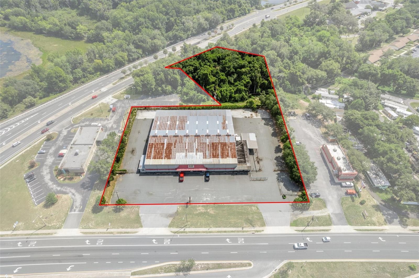 This is a rare opportunity to secure one of the last remaining large parcels in the main commercial corridor. Situated just off the controlled intersection of US Hwy 41/W Main Street interchange (25,500 AADT) and SR 44/E Gulf to Lake Hwy (17,500 AADT), the property spans 3.09 acres with over 330 feet of highway frontage and a combined traffic area of over 71,500 cars daily in the City Limits of Inverness with City Water and Sewer. Zoned C-Commercial allows the highest density of development for commercial enterprise in Citrus County Land Development Code. The subject property is easily accessible, with full ingress and egress via a median curb cut from southbound traffic and right-in access for northbound traffic. It is located at the nexus of W Main Street, US Hwy 41, and SR 44, which connects to I-75 within 15 miles to the east. Current improvements on the subject property include a mixed-use retail and warehouse facility with over 32,608 square feet, 3-phase electric, and 25-foot ceilings in the warehouse area.
It also features two 20’x20’ grade-level doors and full pull-through access for large box trucks and other commercial vehicles. Additionally, approximately 1.9 acres of the site serve as a fenced laydown storage yard. This massive retail hub of Downtown Inverness benefits from a collective pool of consumers from well-known national and regional retailers such as Winn-Dixie, Future Aldi's, Publix, McDonald's, Burger King, and many more. Beyond the retail offerings, you will find the City Hall of Inverness, Citrus County Tax Collectors, Property Appraisers, Department of Vehicles, and the Citrus County Courthouse. The City of Inverness has recently invested heavily in beautifying the town, including the newly constructed lakefront parks: Liberty, Wallace Brooks, and the Depot District.
With the recent $135 million expansion of the Suncoast Parkway and future extensions, Citrus County is poised for historic growth within the Tampa MSA. Just a 15-minute drive from the property, an ideal customer base of 46,361 residents with an average age of 58 and a median household income of $65,000 awaits. Strong market consumer expenditures reveal that 66% of residents dine out at restaurants/steakhouses, and 89% frequent fast-food restaurants. Moreover, given the median age of 58, the area's population has spent over $106 million on healthcare services. The property offers access to flourishing populations in Floral City (5 miles), Lecanto (12.3 miles), Beverly Hills (15.1 miles), Crystal River (16.6 miles), and Homosassa (18.8 miles). As part of Citrus County, currently home to 153,600 residents, the area is projected to experience exponential growth, reaching an estimated 350,000 residents under Citrus County’s Land Development Code by 2030.
Disclaimer: All information provided herein is for marketing purposes only and is not guaranteed for accuracy. Prospective buyers or tenants are encouraged to conduct their own independent due diligence. The seller, broker, and associated parties make no representations or warranties, expressed or implied, as to the accuracy or completeness of this information. All dimensions, zoning details, financial data, and other property-related facts should be independently verified. Please consult with appropriate licensed professionals before making any investment or purchasing decisions.
