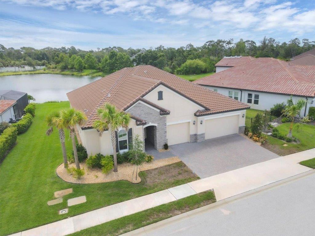 One or more photo(s) has been virtually staged. Welcome to 7228 Great Egret Blvd. ? a beautifully designed Ashwood model by Meritage Homes, nestled in the gated community of Heron Landing in Sarasota. Built in 2022, this expansive single-story home offers 4 bedrooms, 3 bathrooms, and over 3,300 square feet of thoughtfully crafted living space. As you enter you are greeted with high ceilings and an open, light filled floor plan. There is a perfectly positioned office with double doors that can also be used as a playroom, fitness area or with the addition of a closet an extra bedroom. The spacious great room has a wall of sliding glass doors that frame your serene lake views, and is open to the stunning kitchen and breakfast nook. The kitchen is complete with a large island, upgraded cabinetry, stainless steel appliances, a walk-in pantry, built in coffee bar and opens to the separate formal dining room for ease of entertaining or every day living. The three guest rooms are all perfectly appointed; one is in the front of the home with a full bathroom and the other two are located on the opposite side of the home and share a large bathroom. Retreat to the primary suite boasting views of the lake, a large tray ceiling and en-suite with dual sinks and oversized zero entry shower ? the perfect place to unwind at the end of the day. Every detail has been considered with a large inside laundry room, 8? interior doors, hurricane shutters, mudroom/owner?s entry for additional storage, a three-car garage complete with an electric vehicle charger pre-wire and smart home technology with security system, video door bell, irrigation and entry lock all controlled by your phone! Step outside to the extended private covered patio and enjoy peaceful views. If you envision a pool in your backyard, this home has been prewired for a pool and spa; create your own personal oasis with the perfect backdrop. This location is ideally located in a great school district, less than 2 miles from I-75, a short drive to the world-renowned beach of Siesta Key and the vibrant arts, culture and dining of downtown Sarasota.