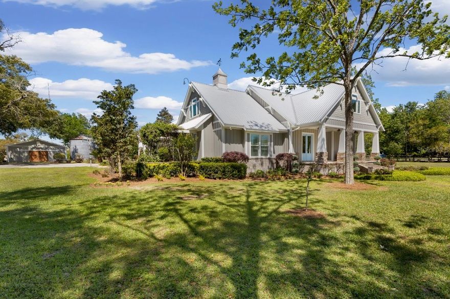 Welcome to a truly one-of-a-kind custom estate in the heart of Gilchrist County, where thoughtful design, high-end craftsmanship, and peaceful country living come together to create an exceptional property. Situated on 4.73 beautifully maintained acres, this 5-bedroom + office, 3-bathroom home offers 2,700 heated and cooled square feet and over 4,000 total under roof, designed for both everyday comfort and elevated living.

From the moment you enter, you’re greeted by warm natural textures and architectural character that set this home apart. A rare 100-year-old hand-carved marble fireplace serves as the stunning centerpiece of the living space, complemented by rich UV oil-finished hardwood flooring, 8-foot interior and exterior doors, and a custom coffered dining room ceiling. A vintage leaded glass window adds a unique touch of charm, while natural light and custom Roman shades create a cohesive, high-end feel throughout.

The chef’s kitchen is both functional and striking, featuring 3-inch thick live-edge granite countertops, a 6-burner gas cooktop with Thermador professional vent hood, and custom cabinetry with LED accent lighting. A breakfast nook overlooks the property, offering peaceful views and a perfect start to your day.

The primary suite offers a true retreat with a spa-inspired bathroom featuring a freestanding soaking tub, surround spray shower system, heated towel rack and refined finishes. Private exterior access leads to a pergola seating area, creating a seamless indoor-outdoor escape.

Step outside to your private backyard oasis complete with a resort-style pool, spacious paver deck, and expansive travertine-tiled front and rear porches. The professionally landscaped grounds include irrigated raised planting beds, a smart-controlled 40+ zone irrigation system, and a variety of mature trees including pecan, oak, magnolia, and fruit trees. Enjoy breathtaking sunrise and sunset views along with abundant wildlife including turkeys, bobwhites, and woodpeckers.

Built for efficiency and longevity, the home features spray foam insulation, 2x6 exterior walls, durable James Hardie siding, and an advanced HVAC system with UV lights and automatic dehumidifiers. Additional features include a 65-ft deep well with maintenance-free water neutralizing system, fiber internet, and Nest smart home controls.

The property also includes an insulated 2-car garage, an additional detached 2-car garage, and a fully equipped 32x72 barn with five roll-up bays, concrete flooring, LED lighting, and custom workspaces. A 380 sq ft mother-in-law suite with full bath, washer/dryer hookup, and mini-split system provides excellent flexibility for guests or extended living. Additional features include a 50-amp RV hookup with septic connection and silo storage.

This property offers a rare combination of luxury finishes, functional acreage, multi-generational potential, and a private setting—creating a lifestyle opportunity that is increasingly hard to find.