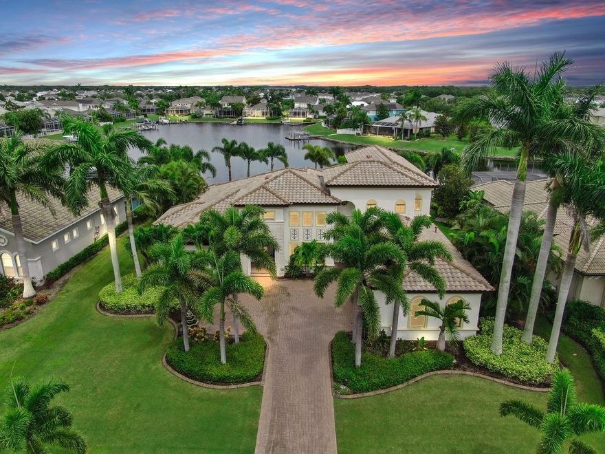 Motivated Seller! Experience the epitome of luxury living in this stunning waterfront Spanish Mediterranean home, meticulously crafted by John Cannon’s Executive Series. Nestled in the prestigious Bay Estate of Mirabay, this residence showcases breathtaking manicured landscaping featuring vibrant pink bougainvilleas, towering palms, and a grand pavered driveway that exudes an enchanting curb appeal. Step through the grand double doors and be transported to a Mediterranean charm and beyond. Every inch of this home is a masterpiece, with artistic hand-painted accents throughout that captivate the imagination. Soaring ceilings, classical columns, exposed wood beams, and intricate crown molding create an ambiance of timeless elegance. Rich Brazilian cherry hardwood floors and authentic Mexican terracotta tiles set a warm, inviting tone. The fully renovated gourmet kitchen is a culinary dream, boasting dark, luxurious cabinets, Brazilian granite countertops, a genuine copper sink, a massive island, state-of-the-art appliances, and a spacious coffee bar/pantry with a beautifully hand-carved Turkish wooden door. The large family room invites you to gather with loved ones, featuring a built-in bar ideal for crafting the perfect cocktail and creating joyful moments with guests. This space is designed for relaxed entertaining and memorable gatherings. The magnificent master suite, featuring a generous sitting area with bay windows, sliding doors to the covered lanai and pool, tray ceilings with double crown molding, and two expansive California closets. The spa-like master bath offers dual vanities, a garden tub as a focal point, and a large walk-around shower, creating a private sanctuary. On the opposite wing, discover two sizable bedrooms with elegant bathrooms, and a convenient laundry room. Notice the custom hand-carved risers as you head upstairs, where you will find a versatile bonus room with balcony access offers stunning views of the sprawling lagoon, while an additional guest suite with its own private balcony provides comfort and privacy for visitors. Other features include, impact windows that offer panoramic views, while providing peace of mind during storms. The upgraded lighting and ceiling fans throughout creates a warm and inviting ambiance, accentuating the exquisite finishes and elegant architecture. Relax and unwind in the serene pool and jacuzzi overlooking the water, or enjoy the multiple outdoor sitting areas. Cozy up by the outdoor fireplace in cooler months or host unforgettable gatherings in the outdoor kitchen and grill area. Included with the property is a meticulously maintained 27-foot Crownline boat, a 2003 model that has recently undergone a complete rebuild, ensuring it’s ready for your next adventure on the water. For seamless access and convenience, a powerful 10,000-pound boat lift is also included, providing secure and easy mooring for your vessel. Whether you’re hosting gatherings, enjoying mornings on the water, or simply savoring the luxurious lifestyle, this property offers the perfect combination of elegance, functionality, and recreational opportunity. Located within the Mirabay community, you'll have access to a host of amenities for every family member—tennis, pickleball, resort-style pools, a large lagoon for water sports, dog parks, playgrounds, and more. This exquisite home offers the perfect blend of artistic elegance, modern luxury, and vibrant community life—an extraordinary place to call home.