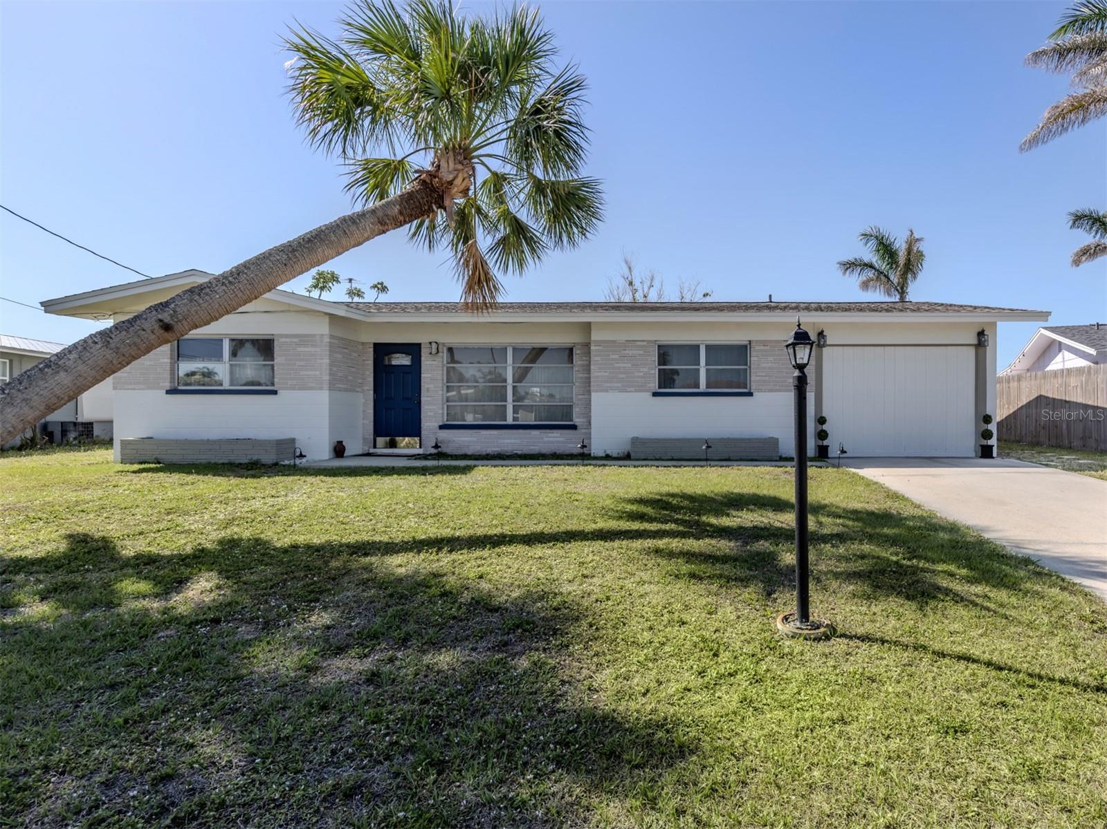 This well-maintained 1,800-square-foot home offers a peaceful and private setting, minimizing traffic and enhancing the sense of retreat. Perfect for those seeking tranquility in their daily lives. The split floor plan which is functional and inviting boasts three bedrooms and 2.5 baths, is ideal for families or anyone who values distinct living spaces. Upgrades include 2024 re-roof, 2024 water heater and 2023 air conditioner. The fact it’s not in a flood zone is a bonus in Florida, providing peace of mind. The terrazzo floors throughout tie into the mid-century aesthetic, offering durability, low maintenance and that iconic speckled look that’s retro and timeless. The formal living room and dining room create dedicated spaces for entertaining or relaxing which is ideal for unwinding with a movie after a day at the beach. The spacious kitchen at the heart of the home is designed for efficiency with extra cabinetry and room for a café table or bakers rack making it a practical yet charming space for cooking and serving those special meals. The primary suite is an owner’s paradise featuring a large walk-in closet and a private en suite that elevates comfort and convenience. The second bedroom, at front of the house also includes a walk-in closet, making it a great option for guests or additional family and near the second full bath making this a modern convenience for family and guests. The third bedroom, at the rear of the home, is versatile enough to double as an office or added space for a blended family, adding flexibility to the home’s layout and near the half bath. The large enclosed Florida room at the back is a standout feature, offering endless possibilities whether as an extra dining space, a second entertainment room or a sunny spot to relax with a view of the large backyard. The laundry room adds everyday practicality, keeping household chores tucked away yet accessible. The outdoor space is a major asset, providing plenty of room for gardening, play or simply soaking in the Florida lifestyle. This home is a rare find, blending mid-century character with modern functionality, all in a prime location. This home benefits from the area’s laid-back coastal vibe, proximity to beaches with just a short drive to the Gulf and a charming downtown with shops and dining.