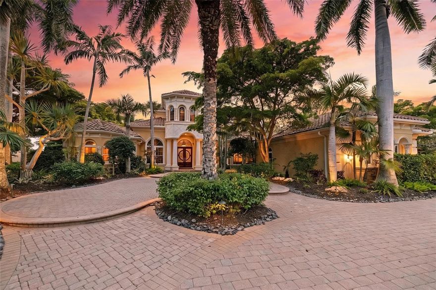 Set on more than half an acre with sweeping golf course views, this extraordinary custom estate by award-winning Pruett Builders is a masterclass in Mediterranean elegance and resort-style living. Tucked within prestigious Lakewood Ranch Country Club, the residence blends architectural artistry, refined craftsmanship, and effortless indoor-outdoor flow.
Mature royal palms and lush landscaping frame a circular paver driveway with a striking compass-rose medallion, leading to a grand columned portico and arched mahogany doors set with beveled leaded glass. Inside, a stunning foyer welcomes you with fluted columns, marble flooring, and a custom mosaic medallion underfoot.
The home's centerpiece reveals itself just steps inside: a breathtaking two-story rotunda anchored by a domed coffered ceiling, crystal chandelier, and soaring arched windows that frame serene views of the lanai and golf course beyond. A dramatic curved wood staircase sweeps to the second level, where a balustraded gallery showcases a custom-built library with floor-to-ceiling bookshelves.
The gourmet kitchen is a chef's sanctuary with custom wood cabinetry, granite countertops, and mosaic tile accents framing a sculptural stone hood. A GE Monogram 6-burner gas range with double ovens, paneled refrigerator and freezer, warming drawer, pot filler, and center island anchor the space, complemented by a walk-in pantry and butler's pantry. The adjoining gathering room flows outdoors through expansive pocketing sliders.
The owner's suite is a private sanctuary with sitting area, plantation shutters, double tray ceiling, and his-and-her walk-in closets with wood built-ins, personal steamer, and ironing center. The spa-inspired bath features a domed ceiling with crystal chandelier, granite vanities, custom maple cabinetry, octagonal marble mosaic floor inlay, walk-through shower, and Jacuzzi tub.
Upstairs, accessible by the curved staircase or private wood-paneled elevator, a spacious game room with wet bar, granite counters, wine cooler, and dishwasher opens to a balcony overlooking the pool and fairways. Additional spaces include a fitness room or guest suite, full bath with steam shower, and dedicated home theater with projector.
Outside awaits a true private resort. A panoramic screened enclosure frames a heated saltwater pool and elevated spa with cascading water feature, all set against graceful Mediterranean arches opening to unobstructed golf course vistas. The veranda and outdoor kitchen feature granite counters, bar seating, refrigerator, grill, sink, and fireplace with cast coral stone surround beneath Cypress wood ceilings; with a spiral staircase to the upper balcony.
Additional luxuries include impact-resistant windows and doors, whole-home surround sound, security system, central vacuum, and a 4-car garage with built-ins and epoxy flooring.
More than a residence, 7202 Teal Creek Glen is a statement of refined living, where award-winning craftsmanship and unforgettable indoor-outdoor spaces converge in one of Lakewood Ranch's most coveted enclaves.