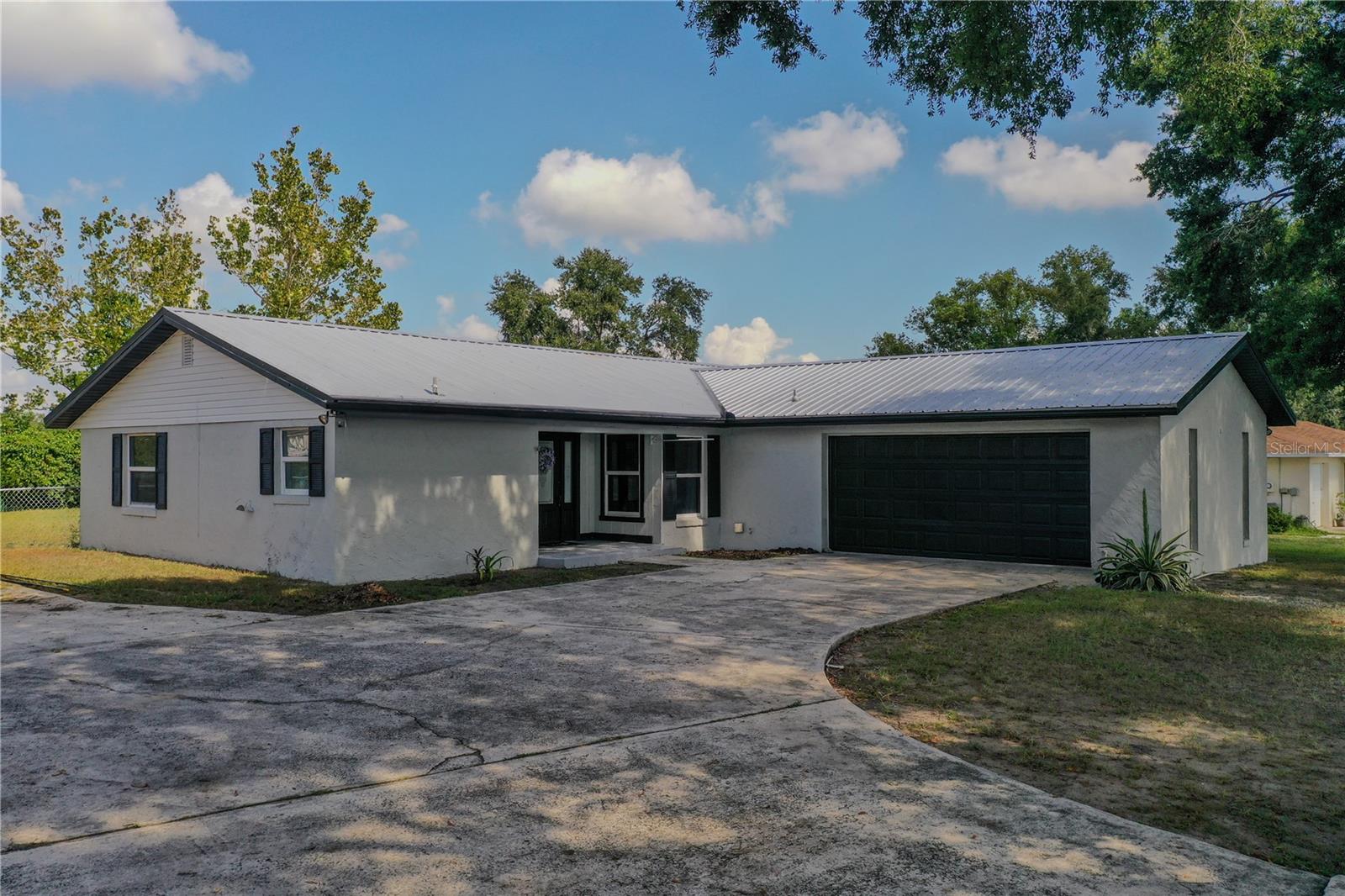 Discover the charm of this inviting three-bedroom, two-bathroom home, nestled in a quiet and established neighborhood. Set on over a quarter acre, this property offers a peaceful retreat, perfect for those seeking a cozy and comfortable living space. As you enter, you'll appreciate the open floor plan that creates a warm and welcoming atmosphere, ideal for family gatherings or simply relaxing after a long day. The entire home features durable ceramic tile flooring, making it easy to maintain and perfect for busy households. The split bedroom layout provides added privacy, making it a great choice for families or guests. The home features tasteful decorative lighting and granite countertops in the kitchen, adding a touch of warmth and practicality to your daily routines. With a two-year-old metal roof, you can enjoy peace of mind, knowing your home is well-protected. The air conditioning system has been recently upgraded, ensuring a comfortable environment, while the five-year-old water heater contributes to the home's efficiency and the septic system has been upgraded to a 3 stage drain field. Step outside to the fully fenced backyard, a perfect space for children to play or pets to roam freely. The included storage shed provides handy space for your outdoor tools and equipment. With a two-car garage and a large parking pad, you'll have plenty of room for vehicles and guests. Schedule a visit today and see how this delightful property can fit your lifestyle!