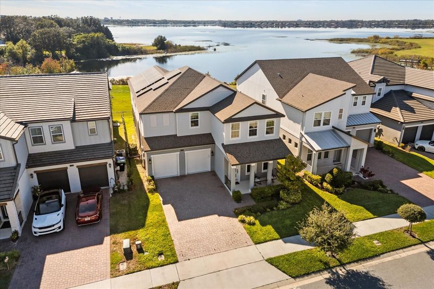 Welcome to beautiful lakefront living in one of Orlando’s most desirable gated communities. Built in 2022 by Meritage Homes, this lakefront home is located in the sought-after Sand Lake Sound community. The fully fenced property includes a paved driveway and a welcoming front porch, offering both privacy and great curb appeal.

The first floor features a private office, a half bath, open living and dining area, and a modern kitchen with a quartz waterfall edge island, KitchenAid appliances, a large pantry, all with views of Big Sand Lake. A first-floor bedroom with a full bath is ideal for guests. Durable hard-surface flooring runs throughout the home, with no carpet for easy maintenance.

Upstairs, you’ll find a spacious loft, a laundry room, and four additional bedrooms. The large primary suite includes a bright sitting area, a private balcony with lake views, a spa-style bathroom, and an oversized walk-in closet. Two bedrooms share a Jack-and-Jill bathroom, an additional full bathroom and all bedrooms have walk-in closets.

The home includes paid-off Tesla solar panels for energy savings. The fenced backyard offers a cover patio, beautiful lake views and nightly Disney fireworks. Community amenities include a resort-style pool, splash pad, playground, boat dock, and dog park. The home is conveniently located near major theme parks and Orlando’s popular Restaurant Row.

Schedule your private tour today, this exceptional lakefront home won’t last long.