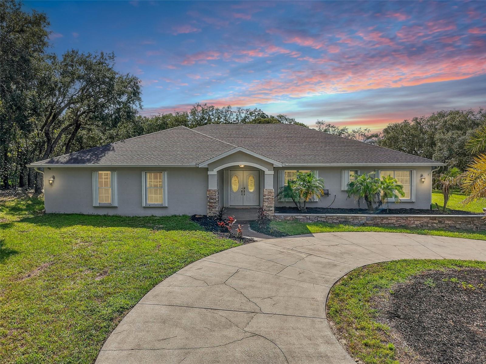Nestled on OVER 11 ACRES in a NON FLOOD ZONE, this incredible 5-bedroom, 3-bathroom estate offers the perfect blend of comfort, space, and outdoor living. A BRAND-NEW ROOF was installed in August 2025 and TWO BRAND NEW WATER HEATERS installed September 2025, giving peace of mind from the start. Inside, you'll find a spacious layout with a large kitchen featuring stainless steel appliances, stone counter tops, a center island, and plenty of room for cooking and gathering. The inviting living area includes a cozy FIREPLACE and a flexible office or den space - ideal for working from home. The oversized primary suite boasts a WALK-IN CLOSET and a luxurious bathroom with a walk-in shower. Step outside to your private retreat, complete with a screened-in back porch, sparkling saltwater POOL, relaxing HOT TUB, and a full OUTDOOR KITCHEN and bar—perfect for entertaining year-round. A volleyball net adds to the fun, while the large covered parking pad that has RV hookup, outdoor storage shed, and circular driveway offer convenience and functionality. The extended, PAVED DRIVEWAY ensures an easy ride up to the house and a clean car! In addition to everything else, the property has multiple fenced in pastures for all future agriculture! An indoor utility and laundry room completes the package. BONUS - there are hurricane shutters on EVERY window! Not only will you enjoy the spacious lot, but you’ll be nearby to the beach for those sunny days! This is a rare opportunity to enjoy true Florida living with room to roam—don’t miss it!