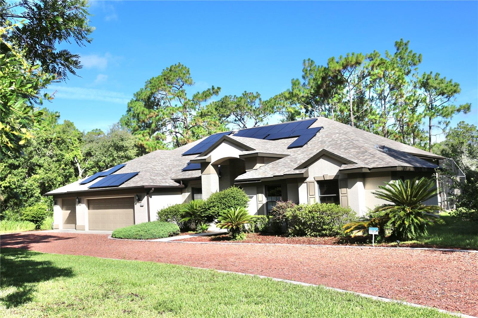 Equestrian Paradise in Pine Ridge Estates! Welcome to your dream equestrian retreat in the heart of spectacular Pine Ridge Estates with 28 miles of horse trails. This beautiful and immaculate updated 2502 sf home with 3 car garage offers the perfect blend of luxury, comfort, privacy and country living. The 2023 roof with solar panels and high efficiency AC will reduce energy costs, which are currently $39 month.This lovely home has spacious living areas for your lifestyle whether in or outside the home. Relax in the the spacious pool or hot tub and watch the horses in their grassy pasture. The horses will love the 3 stall barn with 12 x 12 stalls and the automatic fly spray system. There is an air conditioned tack room, a separate shed for the hay and feed and a convenient wash rack. The riding arena has a sand mix footing for the riding or dressage enthusiast. A separate well feeds the sprinkler system for the pastures and gardens. The Suncoast Parkway provides a 1 hour trip to the Tampa Airport and area.
