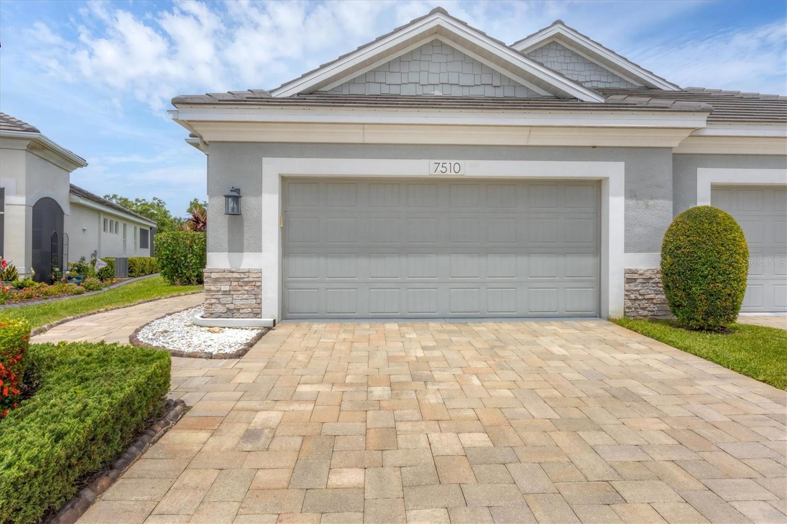 Better than new! Meticulously maintained ANNA MARIA model! Welcome to University Village where you'll find this perfectly positioned villa with beautiful water views. Not all homes in this community are equal... separate yourself from the rest with this GOLD SERIES by Medallion Homes. This means higher quality construction features, energy savings, a load of interior/ exterior features, and complete with an extended, screened-in paver patio. The Anna Maria floor plan offers an open layout with 2 bedrooms, 2 bathrooms, a bonus room, and a 2 car garage. The spacious living area blends seamlessly with the dining and kitchen area, perfect for entertaining. The kitchen is equipped with stainless steel appliances, a natural gas range, white cabinets, solid surface counters, and roll-out drawers in the cabinet spaces. With just the right amount of natural light to compliment the space. In the primary suite you'll find a spacious room, a well appointed bathroom with a walk-in shower, and peaceful views of the pond, with no rear neighbors. The sliding glass doors lead you out to the enclosed patio with a screened in extension, a great space for morning coffee or evening cocktails. This space is just waiting for you to add the outdoor kitchen! The guest room and bathroom are on the other side of the home for maximum privacy. You'll also have a bonus room that is great for an office, media room, or even a 3rd bedroom. No detail left untouched, you'll even have a water filtration system to enjoy. Residents of this gated community enjoy access to a sparkling community pool, great for cooling off in the Florida sun. Not to mention the great location of this home, providing convenient access to all of the areas hot spots including downtown Sarasota, the UTC mall, Lakewood Ranch, and our white sand beaches. Come see for yourself today!