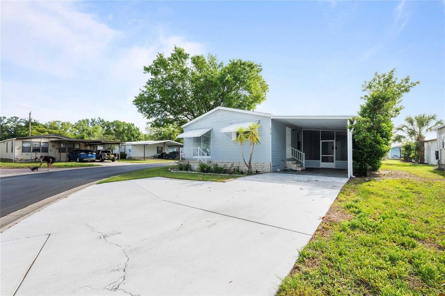 Welcome to Timber Lake Estates – All-Ages Living in Wesley Chapel!
Situated on a desirable corner lot, this well-maintained 2-bedroom, 2-bath double-wide manufactured home offers comfort, functionality, and value in a gated community setting. Step inside to an inviting open floor plan featuring a spacious living area with engineered hardwood flooring, seamlessly connecting to the dining space and kitchen—perfect for everyday living and entertaining. The kitchen includes a breakfast bar and ample cabinetry, while the bedrooms layout provides privacy for guests. The primary suite offers a walk-in shower and generous closet space, while the second bedroom and full bath are ideal for visitors or a home office. Additional highlights include ceiling fans throughout, central A/C, and a screened-in patio—perfect for enjoying Florida’s year-round weather. Outside, you’ll appreciate the covered carport, storage area, and low-maintenance lot. The home is located within Timber Lake Estates, a gated community featuring a clubhouse, pool, playground, fishing dock, and golf cart-friendly streets. With low monthly fees that include water, sewer, and community amenities, plus a convenient location near shopping, dining, and major roadways, this home offers an excellent opportunity for full-time living or seasonal use. No land lease—own your land!