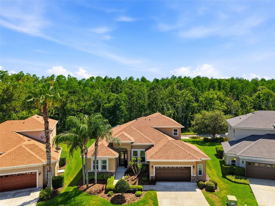 Welcome to the stunning home located in the gated community of Grassglen in Seven Oaks.  Very close to the highly rated Seven Oaks Elementary School and the brand-new Wesley Chapel Library.  This home offers the perfect blend of space, privacy, and resort-style living. This spacious split floor plan features 5 bedrooms, 4 bathrooms, a large bonus room, and exceptional indoor and outdoor living spaces overlooking conservation and a pond. 
 Downstairs you’ll find 4 bedrooms and 3 full baths thoughtfully laid out for both functionality and privacy. The spacious primary ensuite offers a large walk-in closet complete with custom cabinetry. Two secondary bedrooms are tucked away in their own private wing sharing a hall bath, and in the back bedroom closet there is an entrance to additional storage space under the stairs.  The front bedroom with adjacent hall bath creates the perfect retreat for guests or multi-generational living.
Designed for entertaining, the large dining room is ideal for gatherings and is connected to the kitchen through a convenient butler’s pantry. The spacious kitchen offers an abundance of counter space, extensive cabinetry, a pantry, stainless steel appliances, and granite countertops. Overlooking the expansive family room and dinette area, this great room concept creates the ideal flow for everyday living and entertaining.
Upstairs features a large bonus room with a custom built-in desk featuring two workstations, plus an additional bedroom with a large walk-in closet, full bath, and oversized storage closet — perfect for guests, a home office setup, or teen retreat.    This home features a 2 car garage with a bump out which supplies additional storage.  
Step outside to your private Florida oasis featuring a saltwater pool, screened paver lanai, and peaceful views of conservation and the pond.
Seller updates include gutters and French drains (2009), backyard irrigation system and pool (2010), triple pane windows with a limited 30-year transferable warranty (2016), shutters, epoxy garage floor, and exterior paint (2017), pool pump (2022), and a new A/C, water heater, water softener, and roof (2023).
Seven Oaks Residents enjoy easy access to shopping, dining, entertainment, and medical facilities including Shoppes at Wiregrass, Tampa Premium Outlets, Costco Wholesale, Sam's Club, movie theaters, restaurants, and so much more. 
Residents of Seven Oaks enjoy top-tier amenities including a heated Junior Olympic pool, heated resort-style pool, splash park, clubhouse, café, movie theater room, gathering room, tennis courts, basketball courts, playgrounds, sports fields, and miles of scenic nature trails. Ideally located with convenient access to I-75 and I-275 for an easy commute to Tampa and surrounding areas.