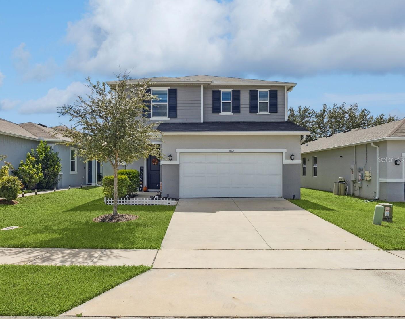 UPDATED AND MODERN HOME WITH HUGE BACKYARD! LIKE-NEW WITH NO CDD! Built in 2022, this Mirabella home features a highly functional, open floorplan layout and is loaded with sophisticated finishings. As you enter, you are greeted with a spacious open concept living and dining space that is ideal for entertaining. The dining area has a sliding glass door with views out to the patio and backyard, and also leads you over into the kitchen. The large kitchen features sleek espresso cabinetry, granite countertops, stainless steel appliances, and huge peninsula with counter seating that is perfect for prep, hosting, or easy dining. There is also a half bathroom downstairs for you and your guest’s convenience. Upstairs, you are met with a large loft space that can be used for an office, game room, movie room and more – make this space your own! There is also an installed privacy shade that can be used to separate the space. The huge primary suite features a walk-in closet, double-sink vanity with granite countertop, large walk-in glass and tile shower, and extra space for a makeup vanity or storage. The two guest bedrooms are located across from the loft, allowing for added privacy, and share their own guest bathroom with long granite vanity and shower/tub with built-in storage. Other features of the home include a large laundry room with sink and under-stair storage space. Stepping out back, you have a large, covered and screened patio with views of your huge backyard! With no immediate rear neighbors, this space can be transformed into your own Florida oasis. The Mirabella community has a low HOA and no CDD, and features a community pool, playground, and green space. The location is prime, with direct access to US-27 providing a short drive to Walt Disney World, I-4, ChampionsGate, Sunset Walk at Margaritaville and several more new restaurants, shops, and entertainment destinations. Come see this home before it is gone!