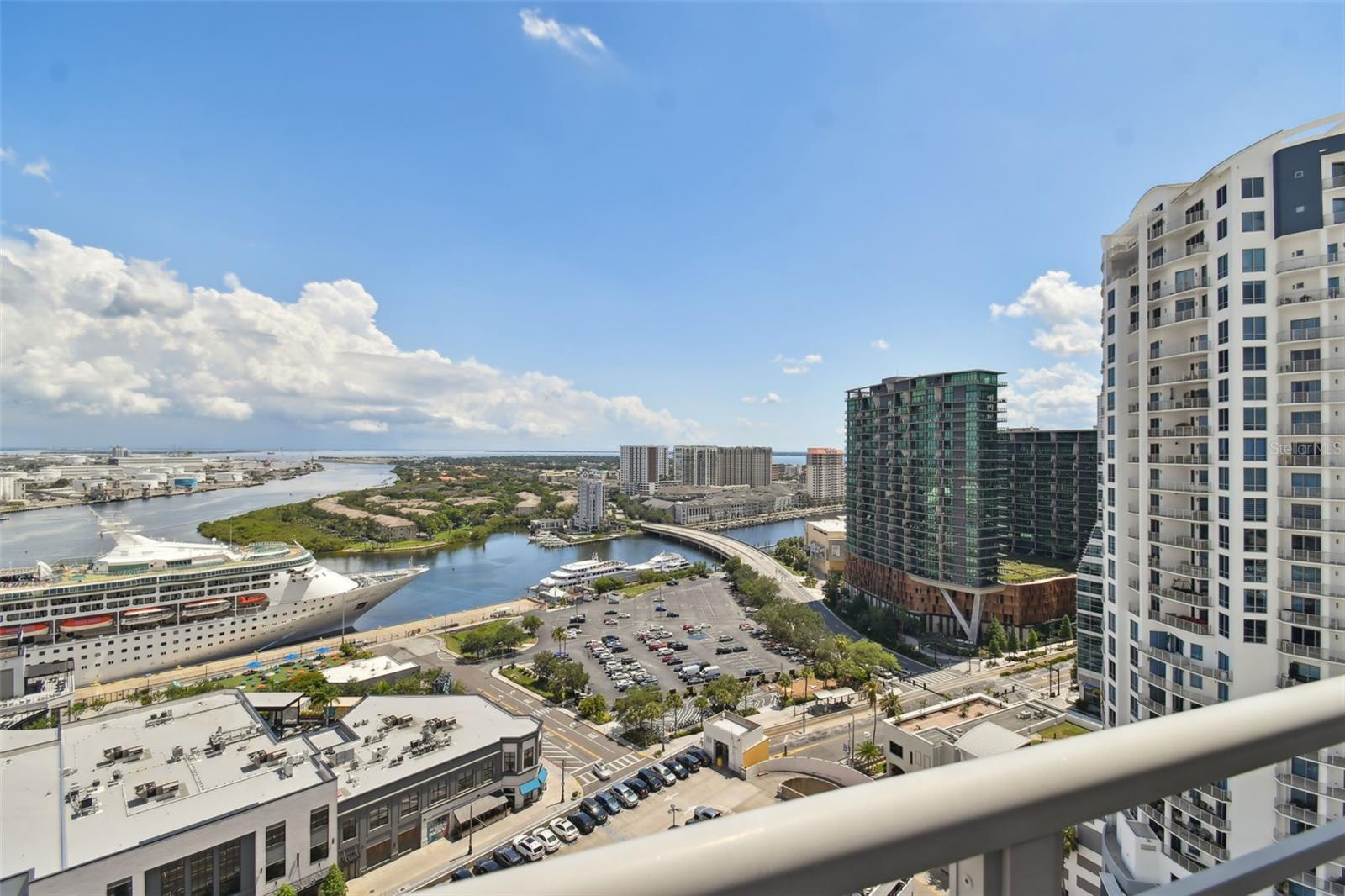 Experience the best views downtown Tampa has to offer with this southwest-facing, 21st-floor unit overlooking Hillsborough Bay, Harbour Island, Water Street, the downtown skyline and even the famous Towers of Channelside pool. This residence exemplifies luxury high-rise living from this contemporarily remodeled unit, with stunning interior finishes. A formal double-door entry opens into a sophisticated interior with new vinyl plank flooring and custom lighting. The versatile floor plan offers over 1,700 square feet of interior space with an expanded primary suite offering an alcove office space. The primary suite is a retreat, complete with a custom closet system and a remodeled en-suite bath featuring dual vanities and a luxury shower. The gourmet kitchen is equipped with stainless steel appliances, granite waterfall countertops, and under-cabinet lighting. Floor-to-ceiling windows and sliding glass doors, fitted with custom roller shades, frame the stunning vistas from every room. Both bedroom suites provide direct access to an expansive 647-square-foot wraparound balcony. Lease includes two reserved parking spaces, a private storage unit, water/sewer, and Spectrum internet and cable. Residents of The Towers of Channelside enjoy an array of generous amenities including 24/7 security, an enormous -fifth-floor resort-style saltwater pool with heated spa and magnificent rock waterfall, two designated dog walk areas, outdoor grill stations, and access to the sizeable clubhouse. The Channel District neighborhood is adjacent to the Water Street District, Sparkman Wharf, the Tampa Riverwalk and Amalie Arena, with numerous entertainment and dining options. An extremely accessible and dog-friendly neighborhood where there are also many additional selections of coffee shops, fitness centers, dog parks and grocery stores.