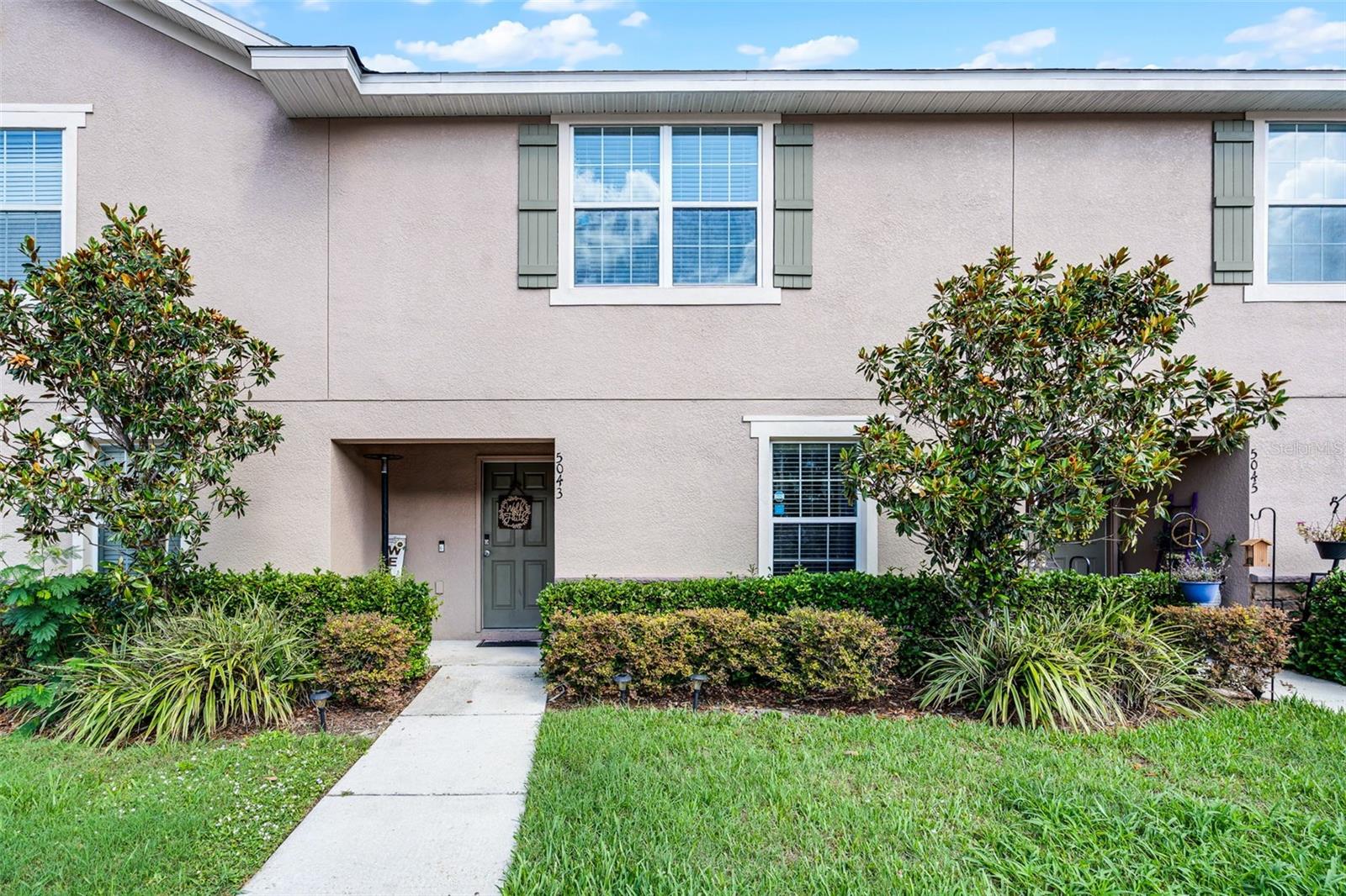 Behind the gates of Santa Fe at Westbrooke, this 4-bedroom, 3-bath townhome offers 1,676 sq ft of comfortable living plus one of the community’s few fully fenced, private backyards—perfect for pets, play, or quiet evenings outdoors. Step inside to an open-concept main level where the living and dining areas flow into a granite-topped kitchen appointed with 42-inch cabinets and stainless steel appliances. A first-floor bedroom with an adjacent full bath is ideal for guests or a home office. Upstairs, the primary suite features a walk-in closet with custom-built-in shelving and a dual-sink bath with a stand-up shower, while two additional bedrooms share a third full bath; the laundry closet is also upstairs for convenience. Residents enjoy a resort-style pool, gated entry, and exterior maintenance included in a low monthly HOA, all just minutes from the Shops at Wiregrass, Tampa Premium Outlets, AdventHealth Center Ice, and I-75/I-275 for an easy Tampa commute. The seller will provide a $2,000 credit toward new flooring. — Let's make this home your own—buyer to verify all measurements and community details.