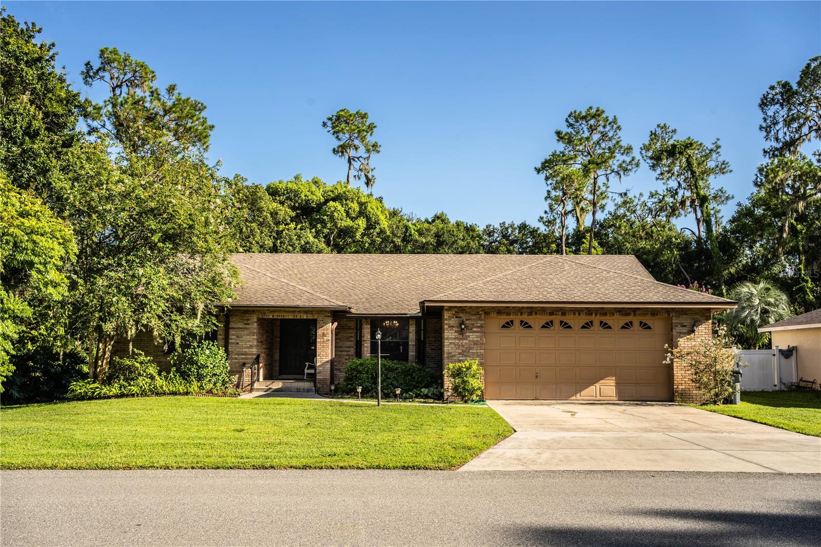 This 1989 custom-built, 4-bedroom, 2-bath home is located in a wonderful southwest Lakeland neighborhood. Get ready to gather the family and friends with no HOA and no through streets! It’s convenient for shopping and the Polk Parkway for access to either Tampa or Orlando. The 2,442-square-foot contemporary-style home is of block construction with a stucco brick exterior and a shingle roof. The .46-acre lot has a private backyard overlooking a wooded view and the 14 x 30 fiberglass inground pool. There are three sets of sliding glass doors that open out to the screened lanai that overlooks the pool. Total square footage under roof is 3,606 square feet. The 546 square foot oversized garage is excellent for both tall vehicles and storage. The interior has a wonderful, tall double-open floor plan with a formal living room and dining room. The large 20 x 10 ft kitchen with a bar and dinette opens to the family room. The family room has a wood-burning fireplace and has sliding doors that lead out to the screened lanai. The flooring is luxury vinyl plank and carpet. The kitchen was recently updated in May 2018 to granite countertops, wood cabinets, and a double sink. Under-cabinet lighting and unique hanging bar lights add to the lovely kitchen decor. The refrigerator, dishwasher, and microwave are stainless steel, and the Jenn-Air stove is black. There is a handy pass-through window from the dinette area out to the screened lanai. Great for parties. The four-bedroom three-bath home has a unique split plan. The master bedroom is carpeted and has a spacious master bath with dual sinks, solid surface countertops, a jetted garden tub, and a separate shower. The tub/shower area is ceramic tile. It also has a dressing area with a walk-in closet with mirrored doors and a linen closet. There is plenty of room for a king-size bed and furniture. Sliders open out to the screened lanai.
There are two guest bedrooms and a guest bathroom adjacent to the family room. The guest bathroom has granite countertops and a walk-in shower. As you walk through the family room to the rear fourth bedroom with its own bathroom, you will see the door leading out to the lanai that leads to the pool. You can access this bathroom from the pool in a wet bathing suit. This extra rear suite is perfect for a private office or an in-law suite.
Two new ceiling fans were installed in the screened lanai in May 2025. The fresh water piping was replumbed in 2018. The A/C was replaced in 2010 and is serviced regularly under an annual contract. The roof is only 4 years old
A new pool pump was installed in July 2024. A new electric breaker panel with surge protection was installed in May 2024. Leaf filters are installed in the rain gutters. Truly Nolen is a transferable termite control contract. Septic tank was pumped and inspected in August 2024. Plywood panels are included for storm protection use on the large sliding glass doors.