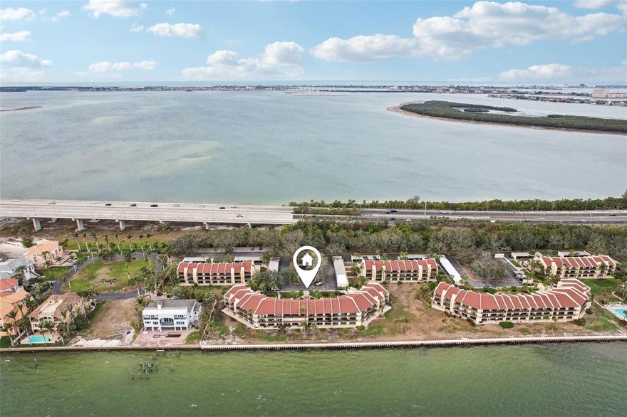 A rare opportunity to experience true waterfront living on Tampa Bay. Tucked within Seapointe Terrace at the southernmost tip of St. Petersburg, this beautifully updated two-story residence, on the 2nd & 3rd floors of the building, showcases sweeping, unobstructed views across Tampa Bay, paired with unforgettable sunrise vistas. The approach to the community is via one of St. Pete’s beautiful, tropical, tree-lined streets and arrive to a setting defined by tranquility and natural beauty. Elevated and unaffected by past storms, the residence offers both peace of mind and exceptional positioning. Offered turnkey and impeccably maintained, the interiors reflect a clean, coastal aesthetic with ceramic tile flooring throughout, softened by thoughtfully placed area rugs. The main living space is anchored by a wood-burning fireplace—an inviting focal point that adds warmth and character. Two generously sized en-suite bedrooms feature walk-in closets and tastefully updated baths, complemented by a well-placed powder bath on the main level. Storage is abundant, with multiple closets, an interior laundry area between the bedrooms, and an additional utility closet. The kitchen is light-filled and functional, offering an eat-in area and breakfast bar that seamlessly accommodates both everyday living and entertaining. Recent improvements include a new water heater, two new HVAC systems, a new roof, newly coated balconies and stairs, and newer impact-rated windows and doors. Residents of Seapointe Terrace enjoy lush, manicured grounds along with a full suite of amenities, including tennis and pickleball courts, kayak and paddleboard storage, a clubhouse, and a heated waterfront pool. Monthly fees cover water, sewer, trash, cable, high-speed internet, and building reserves, providing both convenience and peace of mind. Ideally positioned just minutes from Fort De Soto Park, the Gulf beaches, the Sunshine Skyway, and downtown St. Petersburg—offering access to celebrated museums, performing arts venues, waterfront parks, dining, and year-round cultural events. One covered carport space (#10C) conveys.
