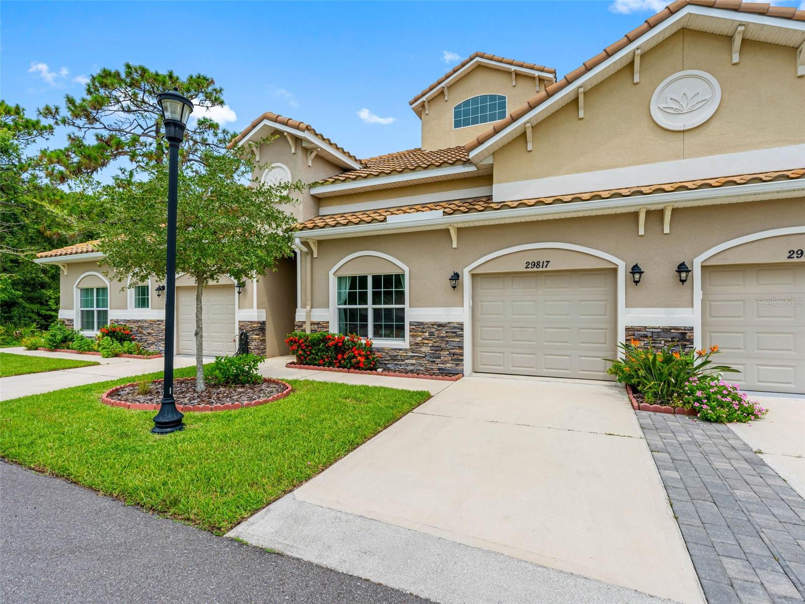 WELCOME HOME to the beautiful and exclusive upscale, senior living Located within Wesley Chapel's Meadow Pointe 55+ of Anand Vihar
Enter through the beautiful gates to the community as security is priority in Anand Vihar. Pull into the driveway of your move in ready newly home and walk down the sidewalk to the front door. Enter into the front door and behold the beautiful ceramic tile which runs throughout the home. Turn left into the beautiful, gourmet kitchen, perfect for the home cook. The kitchen is complete with upgraded appliances, soft close drawers and cabinet doors, lots of countertop space for all of your prep work, and plenty of cabinet space for your gadgets and appliances. With an open floor plan, you will be able to entertain and interact with others in the living room with ease. Just off of the living room enter into the large spacious owners suite featuring crown molding, his and hers walk-in closets, and a beautiful bathroom with a beautiful walk-in shower. Turn right from kitchen you will find access to the garage and laundry, and at the far end you will find a beautiful second bathroom complete with a large walk-in shower. The second bedroom is very roomy complete with a large closet and beautiful windows flooding the room with that fantastic Florida sunshine! The absolute best part is the back, screened in lanai overlooking the private conservation garden view behind the home. Definitely a lovely place for your morning coffee or tea, relax with a good book or just meditate. The community features an amazing clubhouse with meeting rooms, a social area, and a cafeteria where you can order your favorite vegetarian meals or try different dishes from various regions of India. Inside the clubhouse is also a great fitness center complete with separate men's and women's steam rooms. Travel to the back of the clubhouse to find the beautiful, heated pool with plenty of seating. A wonderful place to meet your neighbors and make new friends !! Don't let this home in such a wonderful 55+ community in the heart of Wesley Chapel pass you buy! Schedule and make an appointment today!