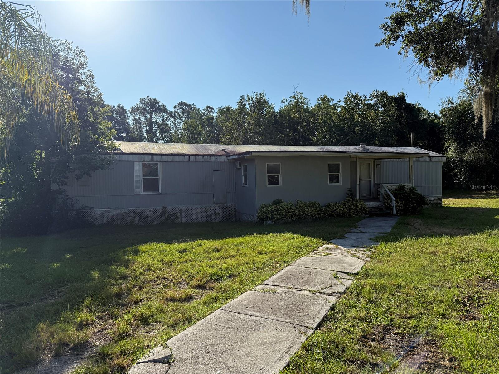 TREMENDOUS OPPORTUNITY! This 3-bedroom, 2-bath mobile home is situated on a spacious 1.4-acre lot and offers endless potential. The home has great bones and is ready for your personal touch—perfect for those looking to renovate and create their ideal living space. You'll appreciate the blank canvas this property provides, allowing you to design it exactly as you envision.
Outside, the property features a standalone 2-car carport and a large workshop equipped with power, ideal for hobbies, storage, or a home business. The expansive lot offers plenty of room for outdoor activities, gardening, or future improvements.
If you're looking for a value-packed property with land and room to make it your own, this is the one!