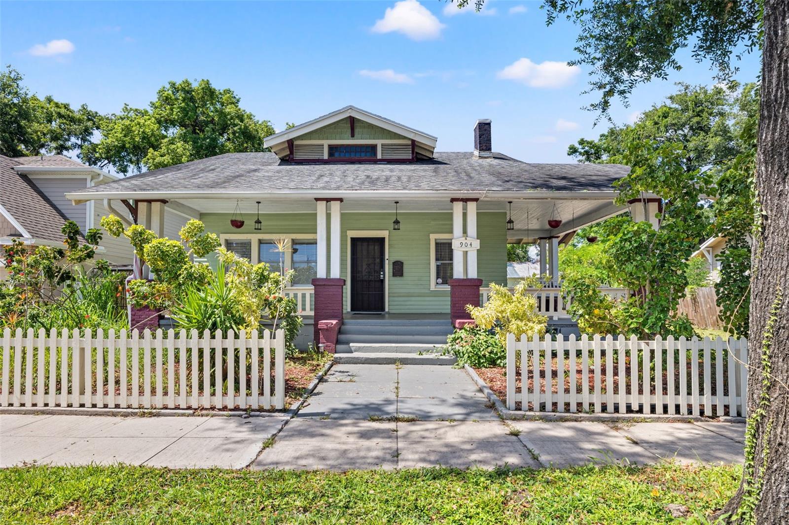 Welcome to 904 E 25th Ave – a charming bungalow for rent in Ybor City. This property is a beautifully maintained 2-bedroom, 2-bathroom gem located in the vibrant heart of Tampa. Nestled between historic Ybor City and the trendy Seminole Heights, this home offers easy access to some of the city's most exciting districts, including Downtown Tampa, Tampa Heights, and the Tampa Riverwalk – just a quick 5-minute bike ride away! Step onto the inviting wraparound front porch, perfect for relaxing in Florida’s sunny weather. Inside, you'll find original hardwood floors, spacious bedrooms, and unique architectural details like built-in glass display shelving that add warmth and character. One of the bedrooms features a private en-suite bathroom. Enjoy the fully fenced backyard, oversized storage shed, and BRAND-NEW washer and dryer conveniently located inside the home. The property can be leased furnished or unfurnished to suit your needs. Lawn maintenance is included, so you can enjoy a low-maintenance lifestyle in one of Tampa’s most walkable and historic neighborhoods. Less than a 10 minute drive to restaurants, coffee shops, breweries, parks, major highways, and the upcoming development GasWorx – this home combines charm, comfort, and convenient location!