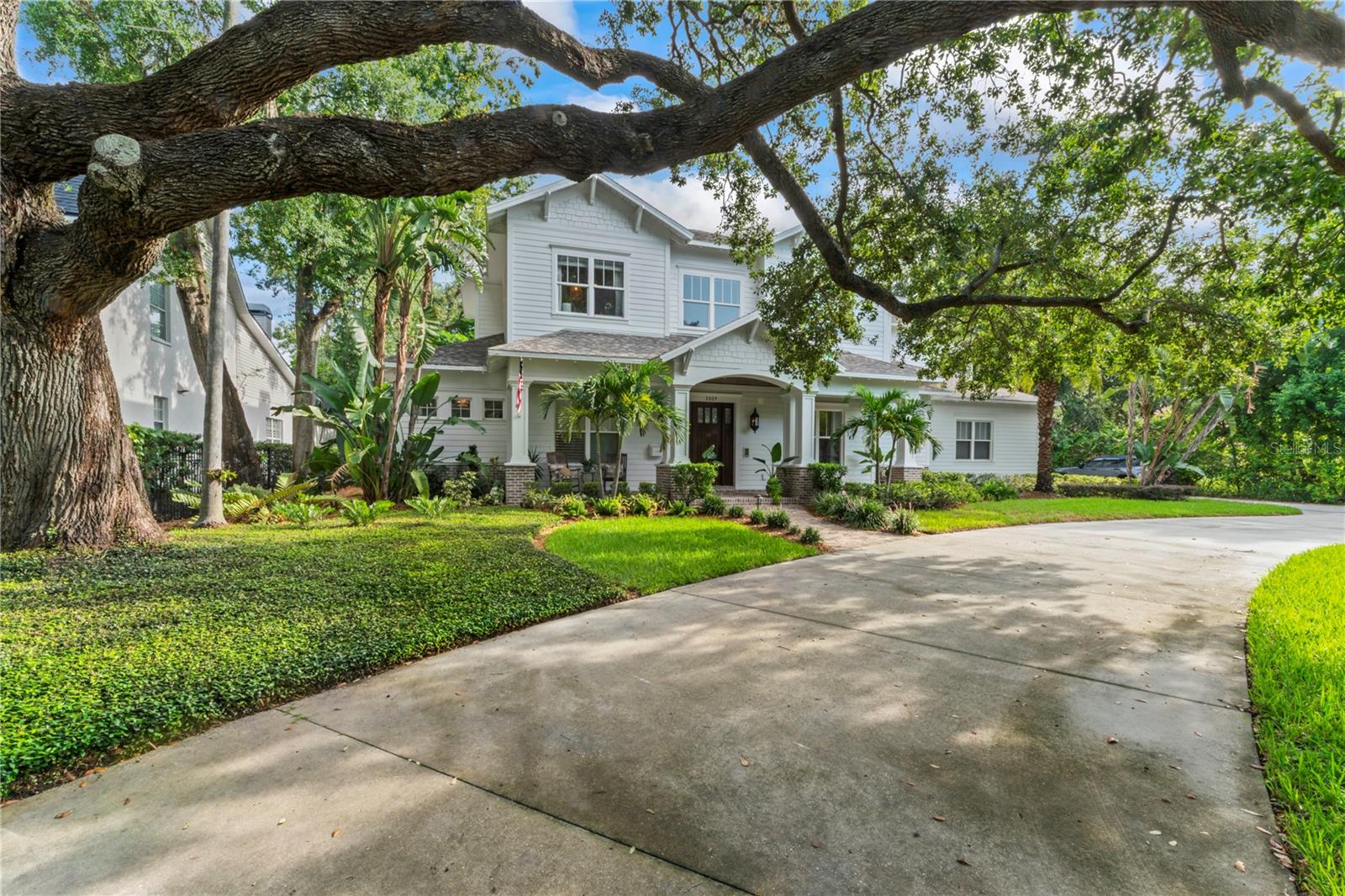 Located in the prestigious Parkland Estates/Golf View neighborhood! NO FLOOD ZONE! Nestled behind a sea grape hedge this “Coastal Craftsman” residence is situated on a huge 120x168ft lot with privacy and space galore including a circular driveway and an oversized 3 car garage. Approaching the front porch, you notice the floor boasts elegant herringbone brick, perfectly complemented by charming gas lanterns that light up the outdoor space. Step inside to discover a breathtaking 2 story foyer with beautifully crafted millwork. Off to your right is the formal dining room adorned with exquisite wainscoting, creating an atmosphere perfect for entertaining. The family room features stylish shiplap walls, a gorgeous tray ceiling, and a cozy wood-burning fireplace. Overlooking the family room is the kitchen where culinary enthusiasts will delight in the double kitchen island, showcasing stunning marble countertops. The kitchen is equipped with a 48-inch Wolf range and a Subzero fridge, alongside a spacious walk-in pantry that caters to all your storage needs. Off the great room is a large built-in bar perfect for entertaining with a wine fridge, an ice maker, and a convenient sink, all set beneath a warm tongue and groove wood ceiling. Step out back through the two double french doors out to one of the most inviting lanais overlooking an enormous, fully walled-in, yard that offers both privacy and security. The covered lanai has more than enough space for a large living area and an al fresco dining space for you to enjoy meals created in your custom brick outdoor kitchen complete with a gas grill and a Green Egg. The lushly landscaped yard is about as large of a space you can find in South Tampa with plenty of space for a pool and additional green space. Retreat to the first-floor master suite, where luxury meets comfort with a tray and inlay wood ceiling and a gas fireplace. The master bath is a spa-like retreat, boasting all marble flooring in a herringbone pattern, complemented by a breathtaking basket weave design in the enormous shower, which features two shower heads for a truly indulgent experience. In addition to the first-floor master, you will also find an additional first floor guest bedroom suite and a home office space. Upstairs you will find a large family/bonus room, an air-conditioned storage room and five additional bedrooms that you can use for whatever you wish! This exceptional home combines luxury, comfort, and functionality, making it the perfect haven. Don’t miss the opportunity to make it yours!