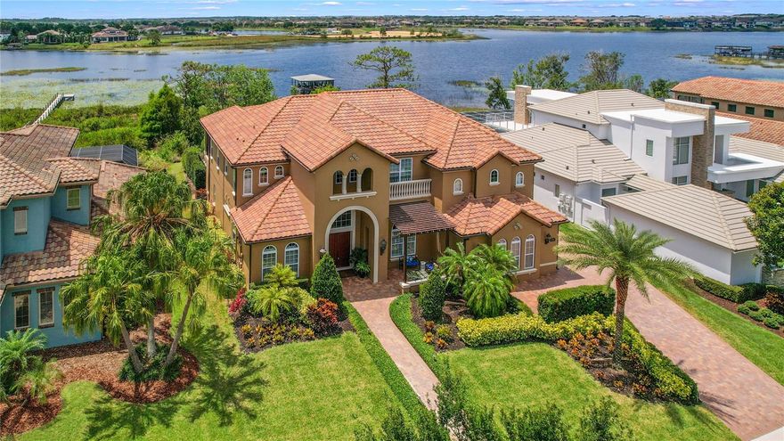 Disney fans, imagine watching the fireworks from your porch, pool, or covered boat dock! Only 15 minutes from the Magic Kingdom, this custom home boasts a rear lake view and front pond view and has all that the Orlando lifestyle can offer! Located in Horizon West with easy access to shopping, restaurants, and highly rated schools. Upon entering, you are met with the grandeur of the beautiful wood staircase, and stunning coffered and tray ceilings. Convenience reigns with double primary bedrooms, double laundry rooms, and an upstairs kitchenette. Entertaining is a breeze in the gourmet kitchen featuring Thermador appliances including a 36-inch dual fuel range, a 30-inch electric oven, and a convection microwave! The pass-through breakfast window makes it easy to enjoy your beautiful outdoor kitchen and generous screened lanai. Feel like you are on vacation year round when you are swimming in the heated saltwater pool or relaxing in the spa and enjoying the lovely view of 475-acre Lake Hancock. Your covered dock easily accommodates two jet skis or a boat and has water and electricity. Come inside and make memories in the huge loft or relax and grab a snack from the kitchenette for a movie in your own theatre complete with SI Black Diamond screen and MartinLogan speakers. The view from the multipurpose room is stunning and can be used as another bedroom. It has an additional attached room with sewing machines and with built-in closet space and room for a bed. This well-maintained home has a lightning protection system, A-NIKS™ mosquito misting system and so much more! Neighborhood amenities include a community pool, gym, tennis courts, and a clubhouse with regular events. Please contact me for a complete list of features.