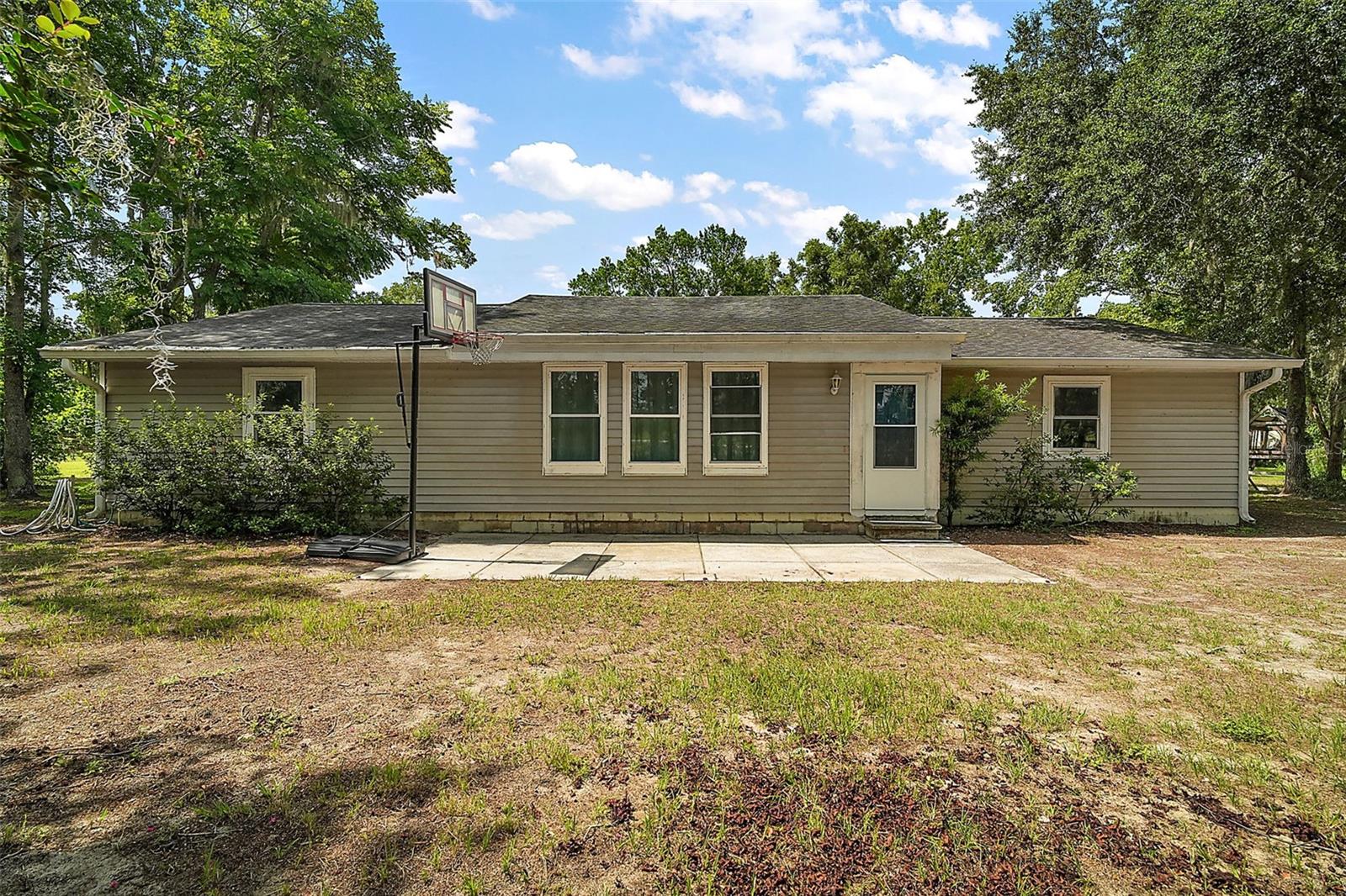 Are you wanting some land to spread out with no HOA fees? Look no further than this beautiful Groveland property on 4.84 acres (3.84 high and dry). The tree lined driveway leads to a 1800 Sq Ft 3 bedroom 2 bathroom ranch style home. The freshly painted home boasts of vaulted ceilings with timber beams, tile flooring throughout, newer windows and plenty of natural lighting in the eat-in kitchen. The master bedroom has an en suite bathroom. The spacious 2nd bathroom has a soaking tub and a new shower. Out the back door is a concrete patio for all of your leisure enjoyment. The roof was replaced in 2017 and double pane energy efficient windows installed in 2020. Wait! That is not all! The property has a massive 25’x 60’ barn that has an office, a storage area, and a workshop for all of your needs. In addition there is even a spot to store your boat or RV complete with an electric hookup. A fenced in area can accommodate your animals. Your shopping needs can be conveniently met in nearby Clermont. Numerous lakes as well as Lake Louisa State Park are close by with Orlando and Disney about 40 minutes away. Hurry and see this exceptional property before it is gone.