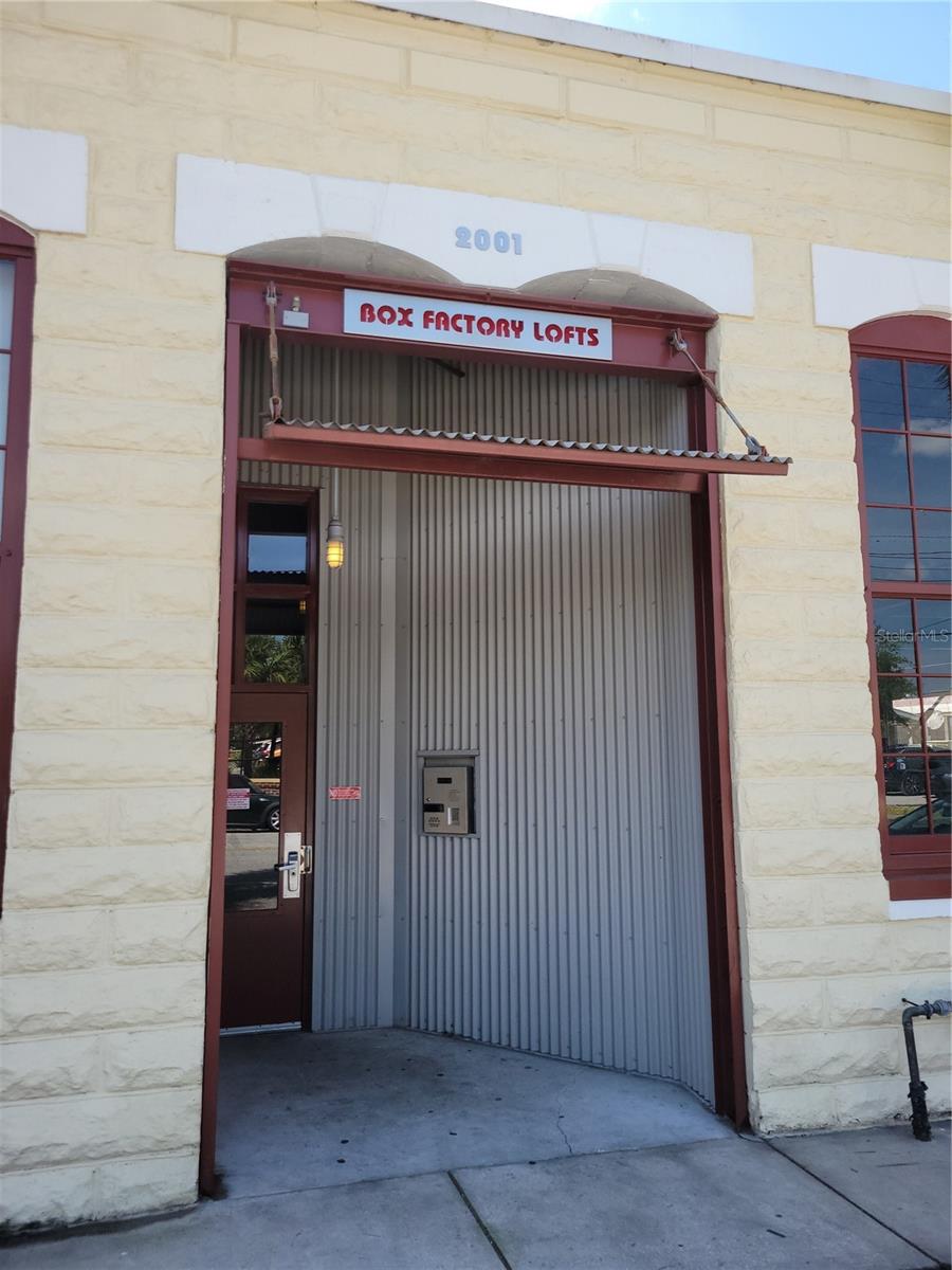 Rare opportunity to lease an historic Box Factory Loft 1BR/1.5BA Condo in the Ybor City area! This unit has a premier covered parking spot! This unit has newer luxury vinyl flooring throughout the 1st floor with newer baseboards, stainless steel appliances, & very nice fixtures to compliment the unit! Enjoy a flex space/office area downstairs, great areas for storage, high ceilings (with striking exposed wood), amazing windows with ample natural light, brick exposure & block walls, granite counters, & an eat-in counter area for guests/gatherings. Your upstairs bedroom area has newer carpet, a custom walk-in closet design, & a washer/dryer. The tension cable & wood railing on the stairs & 2nd floor is urban & industrial. You'll be impressed with the high ceilings, stunning custom window shade designs, & the architectural characteristics of wood & concrete. Box Factory Lofts has an amazing open & light center design to the complex, a bike storage room (climate controlled), a tropical courtyard style pool area (with a restroom), 24 hr. secure entrances/exits with fobbed access, a covered parking garage w/ assigned parking, & ample exterior parking nearby for guests. This iconic building was once a cigar box manufacturing facility in the heart of the Ybor trades & is a fixture in Tampa history! Box Factory Lofts are also in a non-mandatory flood rated area (X).
The building has a 24hr secure system entrance, fobbed entry & call box. Your location is so close to so many options for work & play! Enjoy easy access to the expressway, I-4, Causeway Blvd., a new dog park, walkability to Ybor City locales, a pedestrian/riding trail to Channelside/Waterstreet, the Gas Workx development, Indoor Pickleball Facility, Downtown Tampa, Armature Works, The Riverwalk, & so much more! Enjoy free shuttles downtown, street cars, museums, local art festivals & farmer's markets too! Association application & approval required. No co-signor for occupying tenant credit evaluations - Tenant should have income at or above 3x's the rent, good credit (670+), good rental history (no previous evictions). WATER included in the mo. rent amount.
