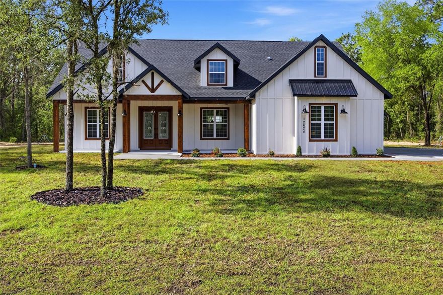 Welcome to this stunning 2026 new construction modern farmhouse located in the desirable Rolling Hills area of Ocala. Sitting on a spacious 1.16-acre lot, this home offers the luxury of being just outside city limits, giving you the privacy, space, and peaceful surroundings buyers love, while still keeping you close to everyday convenience.
Featuring 4 bedrooms, 3 bathrooms, and 2,307 sq ft of heated living space, this home blends modern design with warm farmhouse character. The exterior showcases clean board-and-batten styling, wood accent columns, a covered front entry, and strong curb appeal. Inside, you’ll find an open-concept layout with cathedral ceilings, tray ceilings, ceiling fans, luxury vinyl plank flooring, and tile finishes throughout.
The kitchen is a true centerpiece, offering a large island, modern cabinetry, sleek countertops, pendant lighting, stainless appliances, a range hood, refrigerator, dishwasher, and plenty of workspace for entertaining or everyday living. The living and dining areas flow beautifully together, creating a bright, open space with a luxurious yet comfortable feel.
The primary suite offers a spacious retreat with a walk-in closet and a beautifully designed bathroom featuring dual vanities, elegant finishes, and a walk-in shower. Additional bedrooms provide flexibility for family, guests, office space, or hobbies. The home also includes an interior laundry room, a 2-car garage, central heat and air, and a septic/well setup.
Enjoy the best of Ocala living with nearby access to Rainbow Springs, the World Equestrian Center, shopping, restaurants, and grocery options including Walmart on SR 200. This location gives you the rare balance of country-style privacy with city convenience close by far enough to feel separated from the noise, but close enough to never feel disconnected.