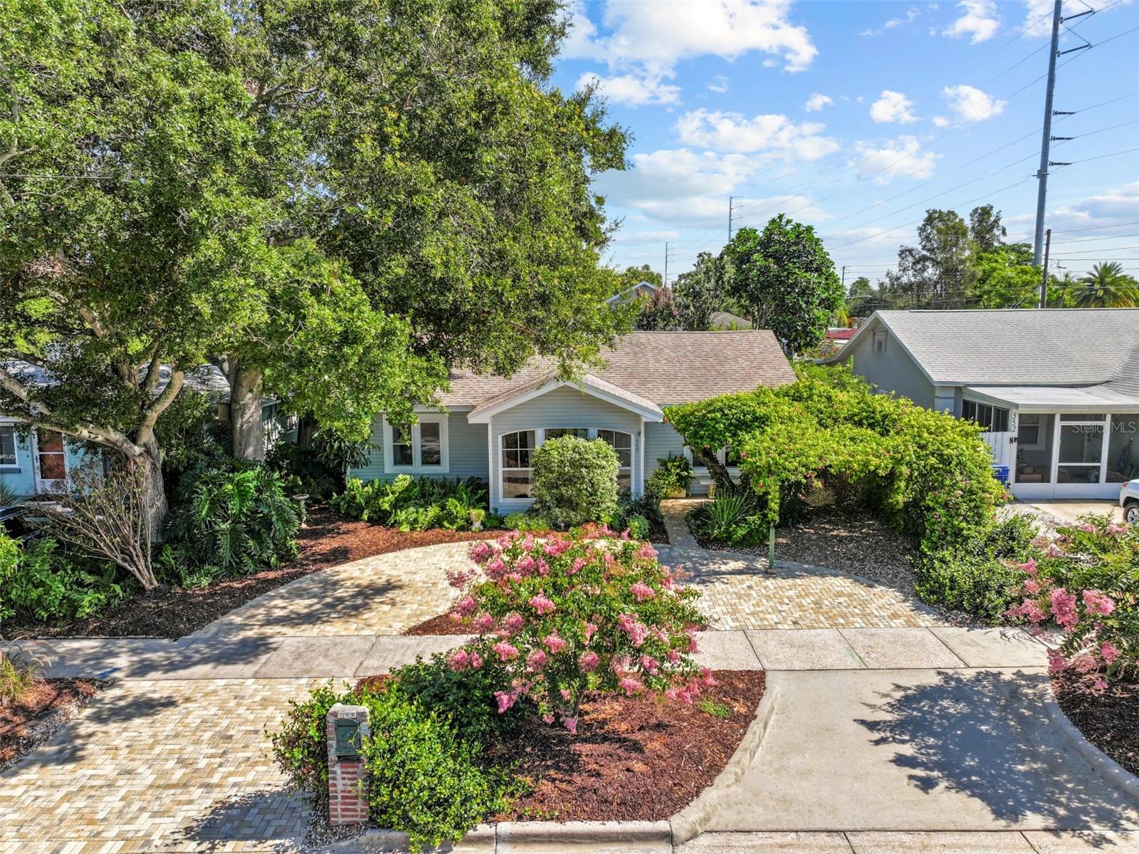 Welcome to your Dunedin dream home – where charm, nature, and location meet. Just 1 mile from Downtown and Edgewater Park, this golf cart lover’s paradise offers the ultimate coastal lifestyle in the highly sought-after Virginia Park. Upon arrival you're met with a brand new paved circular driveway (2025) and a shaded parking area framed by flourishing Bougainvillea. The home is filled with natural light, with a front sunroom surrounded by windows and a skylight in the kitchen that brightens the space. The primary suite features vaulted ceilings, a walk-in closet, and a remodeled bathroom. Two additional spacious bedrooms share a fully renovated bathroom. Enjoy indoor-outdoor living with a 39-foot-wide great room featuring floor-to-ceiling windows and french doors that lead out to a lush backyard oasis, complete with a travertine patio, blooming bougainvillea, and Mediterranean-style garden features. The kitchen has been stocked with new appliances (2025), refinished cabinets with modern hardware. A laundry alcove and extra cabinetry adds convenience. All bedrooms were equipped with Dura Shield hurricane-resistant windows in 2023. Floors upgraded to Brazilian walnut porcelain tile in 2016. Don't miss the chance to own this piece of Dunedin charm.