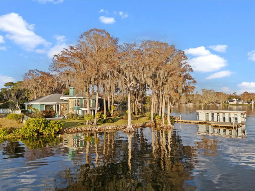 One of a kind and once in a lifetime opportunity! A stunning lakefront peninsula with panoramic views off the north shore of Lake Maitland, the largest lake on the famed Winter Park Chain of Lakes, is now available. The estate is surrounded on 2 sides with approximately 300ft of lake frontage, 1.54 acres total and  .7 acre dry.  The home was designed by Nils Schweizer, a student and representative of Frank Lloyd Wright in Central Florida. Was later renovated adding a pitched roof and screened lanai with a pool/spa overlooking  the lake! The 4 bedroom, 2.5 bath and 3 car-garage home with workshop has an abundance of windows and viewing areas to capture the beauty of central Florida lakes. This unmatched property has sunrise and sunset views looking out to Dog Island, Summerland Avenue tip, and the Isle of Sicily. The paver-drive and walkway lined with crepe myrtles, plumeria trees and hanging stag horn ferns welcome guests to the covered front porch and the dramatic foyer. Steps lead to the upper living room with wood floors, fireplace and 3 walls of glass and a balcony for breathtaking views of Lake Maitland. Nearby is an office with built-ins, ceiling fans and French doors opening to the immaculate landscape. The east wing leads to the primary bedroom having gorgeous views of sunsets, built-ins, fireplace and spacious contemporary bath: oversized walk-in shower, whirlpool tub, dual vanities and closets. Nearby is the dining room and custom kitchen. The dining room has built-ins and glass sliders to covered pool lanai - perfect for al fresco dining with pool and lake views. The kitchen has designer cabinets, granite counters, butcher block island and pass-through window to the pool wet bar. The kitchen sitting bar opens to the family room with wood floors, a breakfast nook and sliders to the screened pool lanai with 270 degree views of water! The north wing has 3 additional bedrooms and a full bath. The bonus room with vaulted ceilings, fans and glass sliders is ideal for a personal gym, theatre, or large den: it opens to either the 3-car garage or paver walkway to the workshop and backyard. A year-round personal resort with noteworthy plants for the gardener, dedicated workshop, hot tub and large pool overlooking the lake The partially enclosed boat house with a sitting deck is a special spot to enjoy sunrises and sunsets! Home’s generator and 250 gallon propane tank assure you of power! Renovate the current home or  start fresh to build your dream home! This property is being sold as-is. The adjacent cleared lot on 125 Whitecaps Circle is also for sale. Purchasing both properties would give the new owner a very unique and stunning peninsula parcel on Lake Maitland on the famed Winter Park Chain of Lakes!
See MLS#O6279215