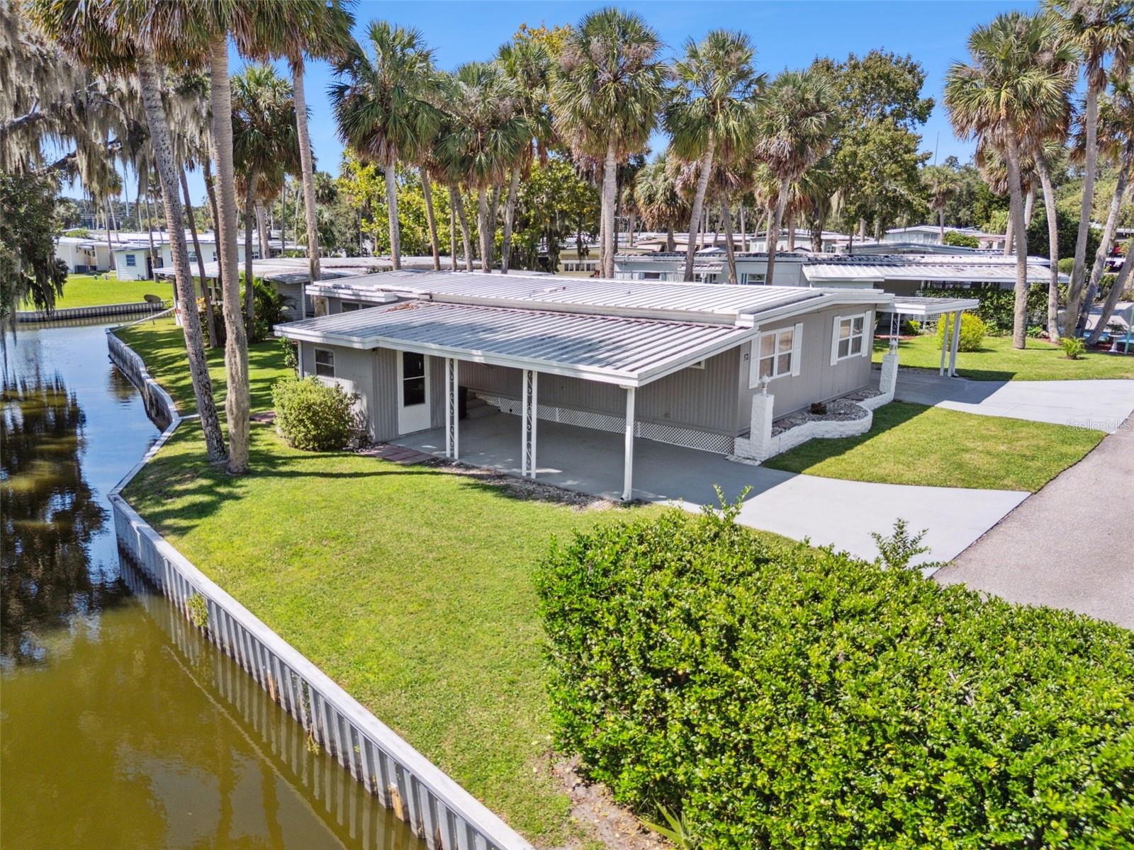 Discover modern comfort and waterfront living at 52 Sabal Palm Circle in Eustis! This beautifully updated 2-bedroom, 2-bath home features an open floor plan with spacious living and dining areas filled with natural light. The sleek, modern kitchen boasts stylish cabinetry, solid-surface countertops, and updated appliances — perfect for both everyday living and entertaining. Enjoy peaceful water views from your backyard with direct frontage on a quiet canal that leads to scenic Trout Lake — ideal for kayaking, birdwatching, or simply relaxing
outdoors. This property also features two covered carports for ample parking and protection from the elements, along with two storage sheds for tools, hobbies, or extra space. Located in the friendly 55+ community of Country Club Manor, this home includes a co-op share with a low monthly fee of just $231, which covers water, sewer, trash pickup, lawn care, and access to community amenities such as the clubhouse, pool, shuffleboard courts, and social activities. Conveniently located in the heart of Eustis, you're just minutes from downtown Eustis, shopping, restaurants, medical facilities, and popular events along the lakefront. You’ll also enjoy easy access to Mount Dora, Tavares, and major highways. This move-in-ready, canal-front gem offers affordable Florida living in a welcoming and active community. Schedule your private showing today!