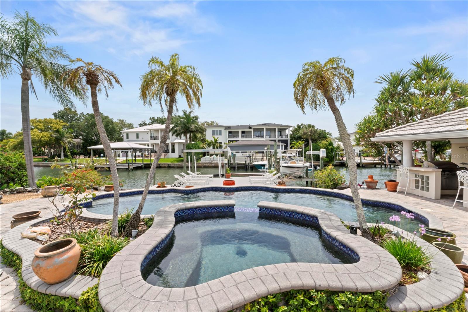 Fantastic opportunity to live on the water on one of the nicest streets off Westshore in Sunset Park Isles! This home was built for entertaining your guests both inside and out! The 3,436 sf floor plan features 3 bedrooms + office/den, 2 1/2 baths inside the home (+ 1 full bath in the pool cabana), a large formal dining room, living room, family room, and a spacious eat-in kitchen with an island. Situated on a large 88x130 ft lot with lovely water views from nearly every room, you will really appreciate the layout. Outside, the resort style pool and hot tub is beautifully designed and overlooks the enormous dock with 2 boat slips with lifts at 12,000 lbs and 13,000 lbs capacity, and a large open deck with even more space for lounge chairs to take in the water views. And who wouldn’t want a poolside cabana bar complete with a built-in grill and full pool bath! You enter the home through attractive double doors with leaded glass sidelights that lead to the large dining room with built-in sideboard. The first floor living room has a wood beam ceiling, a herringbone brick pattern wood burning fireplace and french doors that lead to the screened in porch. The large open kitchen layout has a gas cooktop with stainless-steel hood, full granite backsplash, built-in stainless steel oven, refrigerator and beverage fridge. Just off the kitchen is the laundry room area which doubles as a butler’s pantry with tons of storage and 14 feet of counter space! Other interior features include custom built-in cabinetry in the home office and family room, Brazilian cherry wood floors and travertine tile. There is a sun deck off one of the 2nd floor bedrooms that has beautiful views of the canal and lots of off-street parking on the spacious brick paver circle driveway. Come put your personal touches on this home which could easily be transformed to almost any style!