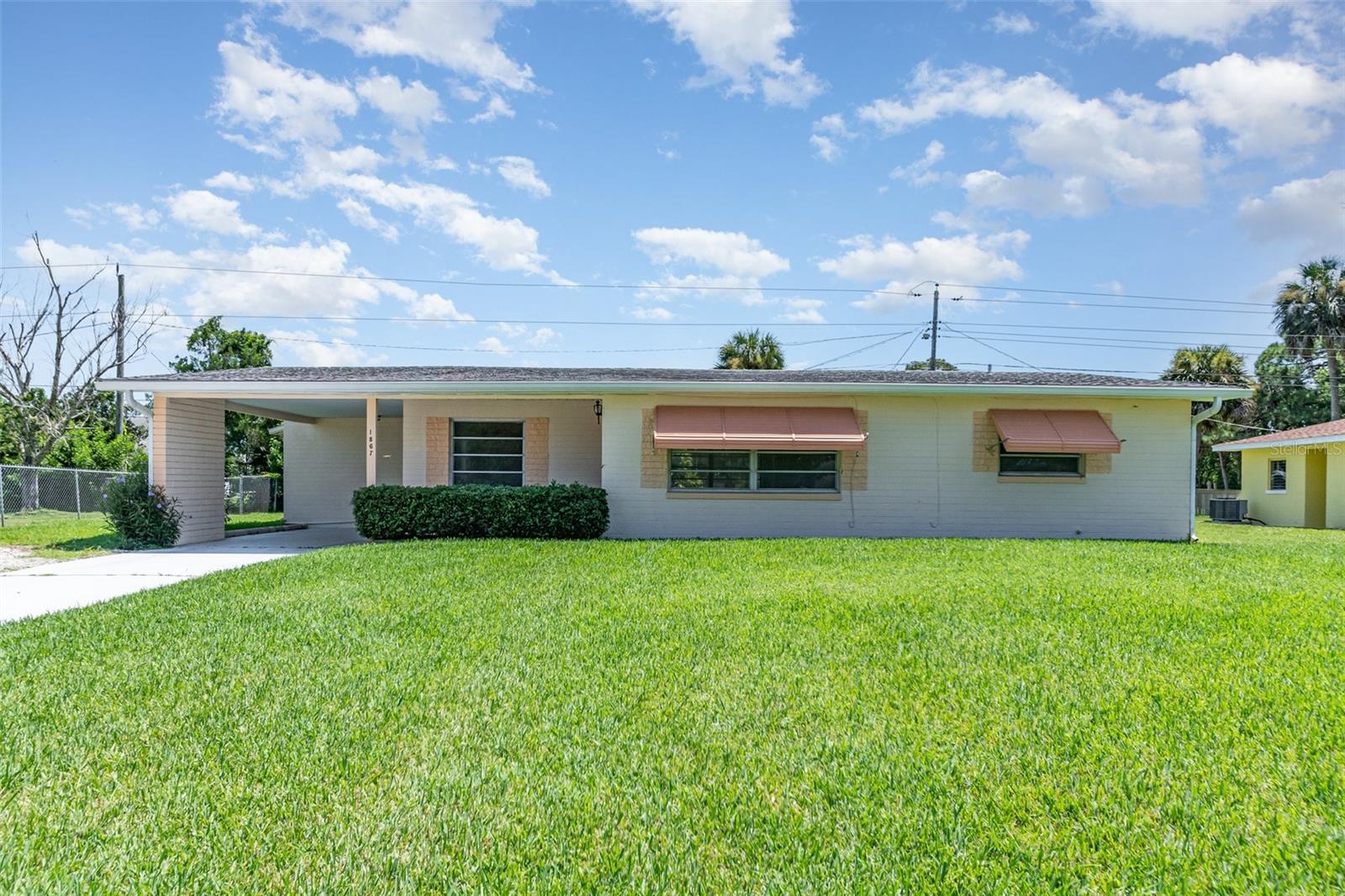 Charming single-family residence featuring an open-concept layout that allows for a smooth flow between rooms. Upon entering, you are greeted by a delightful living room with a lovely window space that offers views of the stunning blue skies, a true FL retirement haven! The residence boasts travertine flooring throughout, complemented by new carpeting in the bedrooms! The kitchen cabinets provide ample storage, with the sink located to overlook the nice porch! The spacious screened-in porch offers plenty of room for an afternoon coffee break, and for children to enjoy and play. The huge front yard is exceptionally green, and the driveway can accommodate up to four vehicles. A sturdy wood and metal shed for extra storage in the backyard! Your roof is about 12 years old, and the HVAC and water heater system are about 15 years old. Location! This property is located in a quiet neighborhood, and conveniently close to beach activities. Make this charming home yours today!