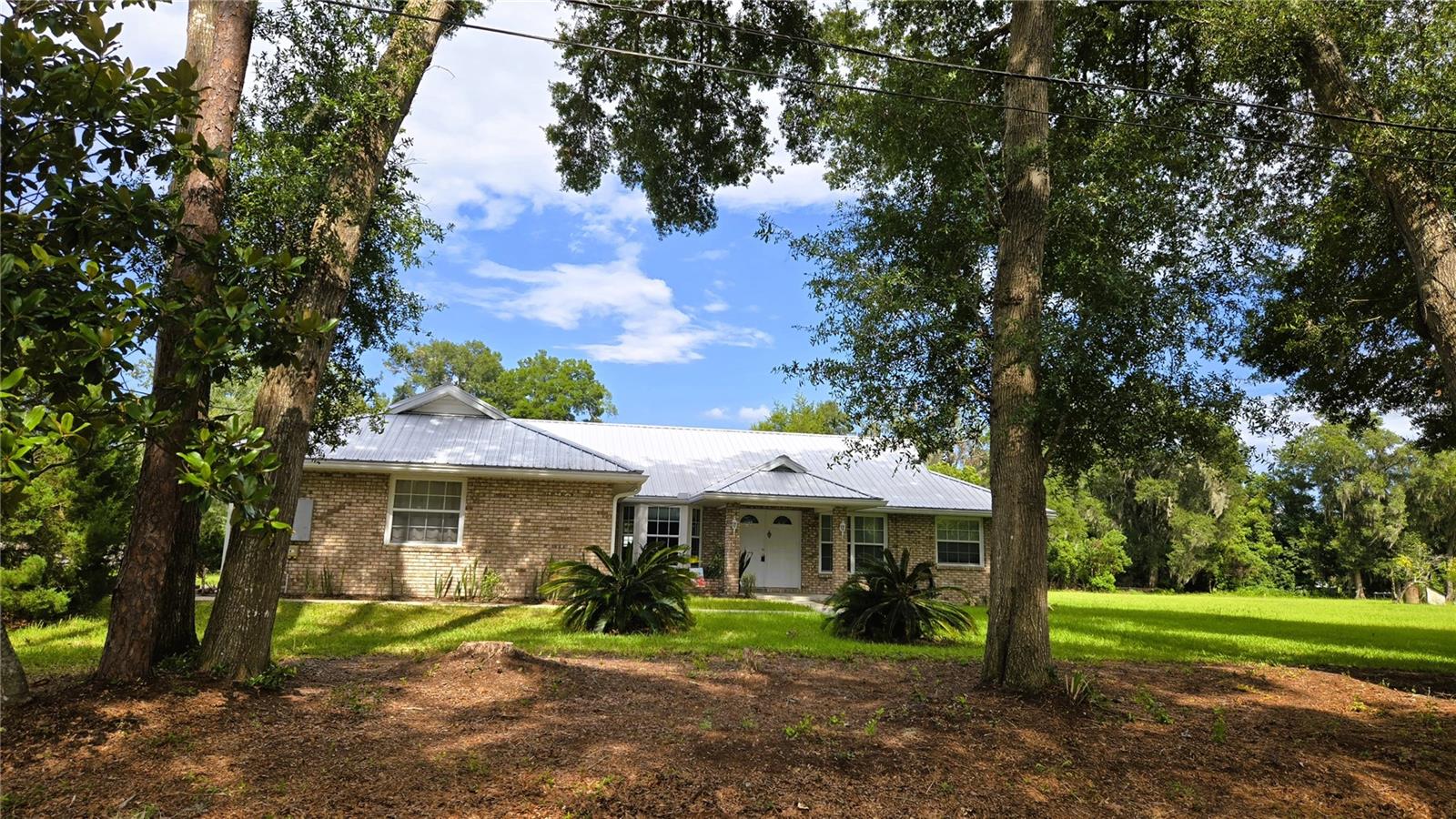 FOR THOSE WHO DREAM OF ENCHANTING DELIGHTS... This home is a dream come true! Family and friends will delight in the warm & welcoming kitchen that is open to the living room with hardwood floors, vaulted ceilings and French doors to the large screened patio. The efficiently designed kitchen has oak cabinets, ample storage & counter space and several surprise features including a pantry, bread drawer, appliance lift and a drawer with a hidden fold-out ironing board! The home has a split bedroom plan and an inside laundry room. You can enjoy lazy afternoons on your porch swing in the screened patio or step outside and pick your own fresh pineapples! In addition to all the inviting features of the home there is an attached 2 car garage with built in shelving and a 2nd detached garage with a workshop area & 1/2 bath. PLUS the property includes 2 LOTS for a total of 1.43 Acres. You can keep all the land or subdivied to create possibly 2-4 lots to sell seperately. CALL TODAY, TO SEE WHAT'S IN YOUR FUTURE!