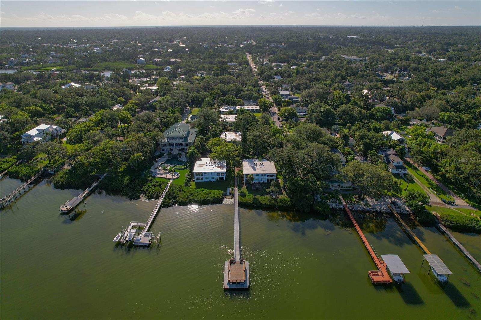 Your Slice of Paradise in Ozona ~ Waterfront Living at Magnolia Condos! Step into your very own tropical escape with this beautifully designed 2-bedroom, 2-bathroom waterfront condo in the heart of Ozona. Nestled in the very special and laid-back Magnolia community, this ground-floor gem sits high and dry at over 17 feet above flood elevation ~ offering rare peace of mind and everyday luxury with absolutely stunning water views. From the moment you enter, you'll be greeted by bright natural light and lush greenery framed by every west-facing window with waterfront views ~ Bringing the outdoors, inside! The open-concept great room flows effortlessly, creating a warm and welcoming space perfect for relaxing or entertaining. The family room is the heart of the home, where you can unwind and soak in vibrant sunsets or open the custom remote-control shade to reveal breathtaking views of the water and tropical foliage. Love to cook? You’re in luck. The kitchen is a dream ~ fully custom with crisp white cabinetry, designer hardware, quartzite countertops, a gleaming glass tile backsplash, pull out drawers, a lazy Susan and water views that will make washing dishes feel like a treat. Engineered hardwood and tile flooring run throughout the home, blending style and function with ease. Both bathrooms shine with quality craftsmanship and stylish finishes, offering a spa-like experience every day. Plus, enjoy the convenience of a covered breezeway entrance with a storage closet and a stackable washer/dryer tucked inside. The condo also comes with a covered carport ~ perfect for your car and your kayaks.
Did we mention it’s being sold furnished? Just bring your suitcase and settle into the Florida lifestyle. The Magnolia community is truly a hidden treasure. Direct access to the Gulf of Mexico awaits from the 200-foot private dock or kayak ramp ~ no flood insurance needed. HOA dues cover just about everything: exterior maintenance, water, sewer, trash, building insurance and of course, those unforgettable sunsets.
Located in the golf cart-friendly village of Ozona, you’ll be steps from the 47-mile Pinellas Trail, funky local shops, live music and award-winning restaurants. You're minutes from Downtown Palm Harbor, Dunedin and the famous Sponge Docks of Tarpon Springs. With nearby marinas, championship golf courses and a calendar full of fun local events like Ozona’s Third Thursdays, there’s always something to enjoy.
Don’t miss this rare opportunity to live the waterfront dream ~ schedule your showing today and discover the true meaning of coastal living and start Living Your Best Florida Lifestyle Today!!
