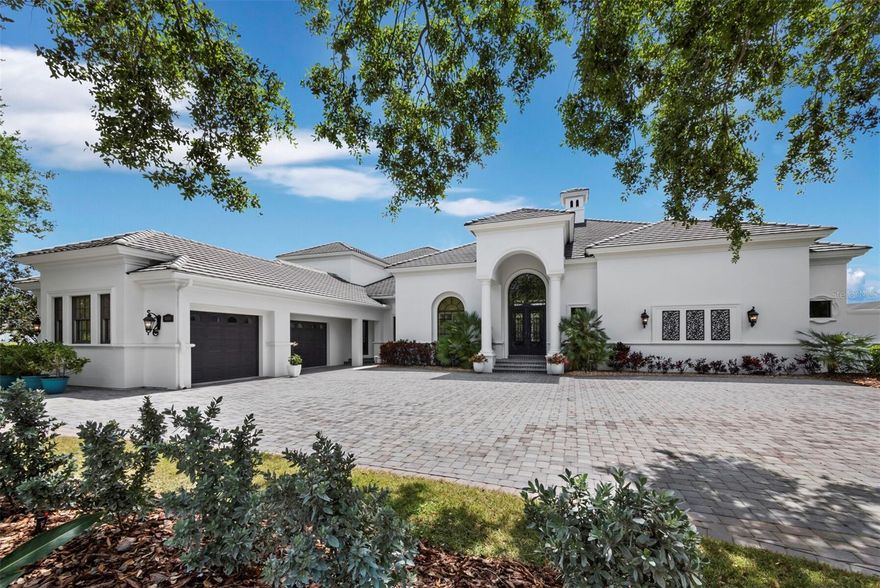 Set along the 11th green within the private, guard-gated Founders Club, this custom residence by John Cannon Homes captures sweeping golf course, lake, and preserve views across a beautifully positioned .69-acre homesite.
Spanning over 5,700 square feet, the two-level design is both elegant and highly livable, with soaring ceilings, detailed millwork, and a natural flow that supports both everyday comfort and large-scale entertaining. A gracious foyer introduces formal living and dining spaces, while the heart of the home opens to a spacious family room and chef’s kitchen featuring premium appliances, a Wolf gas cooktop, oversized island, walk-in pantry, and a sunlit breakfast area framed by aquarium glass overlooking the water and fairways.
Walls of French doors create a seamless transition to the expansive screened lanai, where the pool and spa, outdoor kitchen, and covered living areas are surrounded by tranquil views—an ideal setting for quiet mornings or evening gatherings.
The primary suite is thoughtfully designed as a private retreat, complete with a sitting area, custom office, dual boutique-style closets, and a spa-inspired bath with hydrotherapy tub, oversized shower, and dual water closets. Two additional guest suites are positioned in a separate wing for privacy.
Upstairs, accessible by elevator or stairs, a generous bonus room with wet bar, fireplace, and full bath opens to a terrace with long, open views across the course—easily adaptable as a fourth bedroom or private guest quarters.
Additional highlights include a wine cellar, butler’s pantry, travertine and hickory flooring, coffered ceilings, impact-rated openings, and a four-car garage.
The Founders Club spans 700 acres of preserved natural beauty, offering a refined yet relaxed lifestyle with optional membership to its Robert Trent Jones Jr.–designed championship golf course, clubhouse, dining, fitness center, and tennis and pickleball amenities.
A home defined by scale, setting, and architectural integrity—positioned within one of Sarasota’s most established private communities.