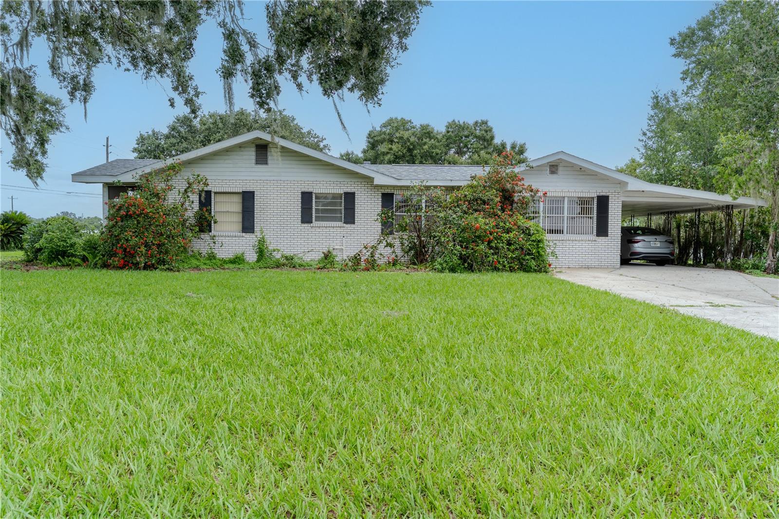 **NEW ROOF** Welcome to this 3-bedroom, 1-bathroom home, featuring a brand-new roof and freshly painted fascia, situated on a spacious corner lot. It offers a fantastic opportunity for those looking to infuse their personal touch and transform it into something special. Inside, you'll find a layout with high ceilings and ceiling fans that create a sense of space and comfort. The split-bedroom design adds to the functionality, while the open living room/dining room combo presents a versatile area for gatherings and relaxation. The home comes with solid wood cabinets and ample storage options, including a generous walk-in closet in the primary bedroom. Step outside to enjoy the screened porch, a perfect spot for soaking in the Florida sunshine, or cozy up on the front porch with a good book. The property also features a covered carport and convenient level parking, making daily life easier. Whether you're embarking on your homeownership journey or seeking a comfortable space to downsize, this home presents a unique canvas for creating lasting memories. Don’t miss this chance to make it your own—schedule a showing today!