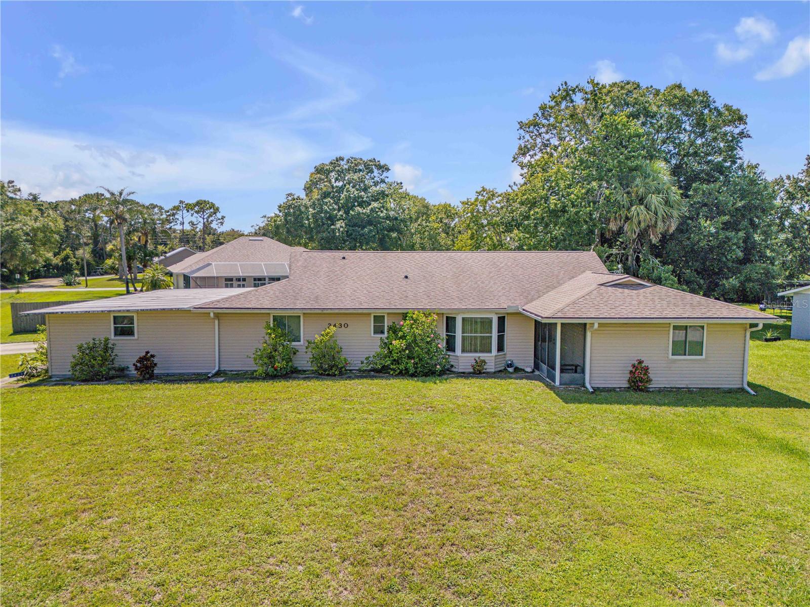 Welcome to 2430 Unity Tree Drive, a charming ranch-style retreat nestled in the welcoming Florida Shores neighborhood of Edgewater. This delightful 3-bedroom, 2-bath home spans 1,462 square feet of comfortable living space and is situated on a lush, oversized .34-acre lot—perfect for outdoor living, gardening, or creating your own private haven. Constructed in 1987 with sturdy wood-frame and vinyl siding, the home features efficient forced-air heating, an asphalt shingle roof, and classic design elements like cathedral ceilings, a split-bedroom layout, and a whole home generator. Inside, discover a sunlit, open living space designed for both function and connection. The generous bedrooms offer comfort and privacy, while the home’s layout flows effortlessly for entertaining or simply enjoying everyday life.