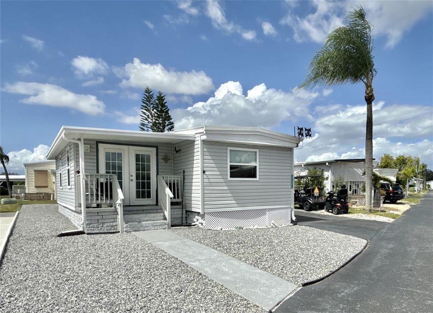 Cozy and comfortable! No Flooding! This 2 bed/1 bath home with almost 900 sq. ft of living space was totally remodeled in 2019 and has been lovingly maintained since.  The features are many: 2024 beautiful laminate flooring throughout with new flooring in bath in 2025, 2019 double paned windows throughout, 2024 membrane roof over keeps the home cool, 2024 vapor barrier to protect the subflooring, 2023 energy-efficient mini split in living and window AC in primary bedroom, 2025 plumbing throughout, updated kitchen with newer appliances and updated bath with walk-in shower and two closets. Washer and dryer in utility shed. Long carport holds two cars easily and additional parking for golf cart. Decorator maintenance-free rock on three sides completed in 2024. Termite warranty. Comes partially furnished. Price includes share for the lot and ownership in the co-op. Home is located in the premier 55+ community of Americana Cove, located only 10 mins from downtown St Petersburg, 5 mins from 4th St groceries, restaurants and shopping and 20 mins to airports. Low monthly maintenance fee of $380 includes water, sewer, trash pick up, lawn mowing, 24 hr manned gate, private streets and all amenities including heated pool, clubhouse, fitness center, billiards and so much more! Great home for investor as renting is allowed with 2 month minimum! 2 dogs or cats up to 35 pounds are welcomed; 2 pets total each household. So much home for so little price! Management requires 675+ credit score.