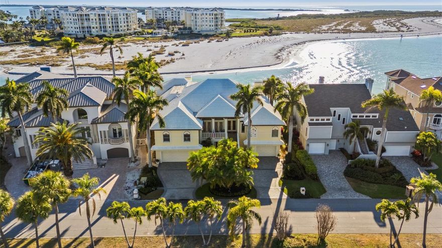 Welcome to Vita Sul Mare! Located at the end of Dent’s Channel and offering breathtaking panoramic views of the Gulf, this remarkable home truly captures Life By The Sea. After enjoying time on the boat or beach, you can relax in the waterfront pool and spa. The expansive fiberglass dock provides water, power, and mooring for multiple large vessels. Inside, a grand foyer greets you and highlights the custom features throughout the residence. The formal living and dining rooms feature coffered ceilings and beautifully crafted plaster walls, with views over the channel toward the Gulf. The chef’s kitchen includes gourmet appliances such as SubZero refrigeration and a Wolf range with double oven and marble hood. Host guests at the breakfast bar, plan events at the built-in desk, and make use of the ample pantry storage. Step from the kitchen onto the grilling porch equipped with a built-in BBQ and spiral stairs down to the garden level. The Great Room is designed with coffered ceilings, a stone fireplace, and etched glass transoms above large picture windows. Among the five bedrooms and five full baths, the master suite stands out with its cozy fireplace and luxurious spa bath. This distinctive ensuite offers dual vanities, walk-in closets, wardrobes, and water closets, as well as a jetted tub and a separate shower featuring multiple shower heads. A spacious balcony extends from the main living level, accessible from the Great Room, Living Room, and Master Suite, and connects via stairs to the pool, dock, and a large covered lanai with an outdoor kitchen—ideal for entertaining. On the enclosed lower level, behind custom doors, you’ll find a wine cellar with brick walls and domed ceilings, creating an enchanting setting for your collection. This area contains over 4,000 square feet of flexible space, including two garages that accommodate up to five vehicles and plenty of room for a home gym.  With fortified concrete construction and storm shutters, this home is a fortress in a fisherman’s paradise!