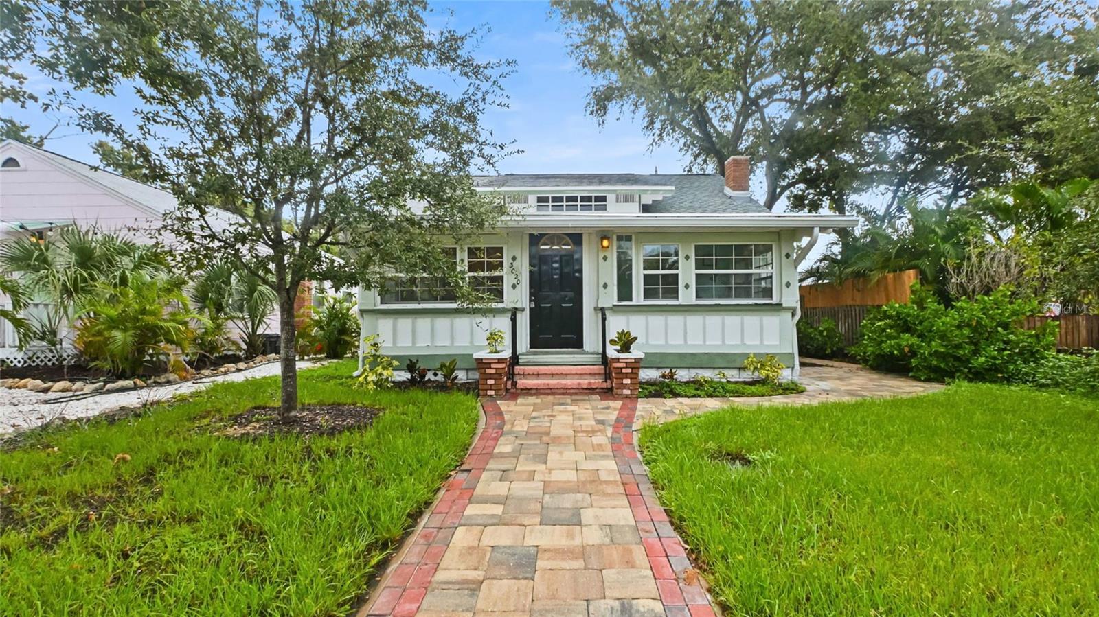 Step into a piece of Gulfport history with this charming two-story Craftsman bungalow, perfectly positioned just moments from the beach and vibrant Art District. The open and flexible floor plan showcases the home's original historic charm, from the decorative brick fireplace to the custom built-in bookshelves, desk, and classic hardware. A spacious front Florida room provides a sunlit welcome, while the den offers an ideal home office space. Climb the stairs to discover the hidden gem—a massive 12'x25' finished attic bedroom. Outside, enjoy the serene, new paver walkways and lush landscaping, all beautifully framed by mature trees. A backyard shed with a washer hook-up, alley access, and a convenient parking pad complete this delightful property, all just steps from Gulfport's best restaurants, shopping, and nightlife