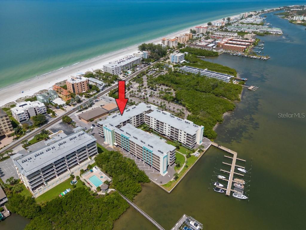 Discover the ultimate in waterfront living with this beautifully updated and fully furnished two-bedroom, two-bathroom condominium at Golden Shores in Indian Shores, Florida. Over the past two years, this spacious residence has been tastefully enhanced with luxury vinyl plank flooring, textured ceilings, updated light fixtures, new closet doors, new trim, new vanities, and fresh interior paint, creating a sleek and contemporary coastal retreat. The gourmet kitchen is both stylish and functional, featuring granite countertops, a new tankless reverse osmosis water filtration system, in-ceiling lighting, a pantry closet, and a convenient stackable washer and dryer. The open-concept layout seamlessly connects the kitchen to the dining and living areas, where expansive windows provide abundant natural light and stunning views of the pool and Intracoastal Waterway. The oversized primary suite offers direct balcony access, dual closets, updated Vertiglide shades, and a beautifully renovated en-suite bath. The generously sized second bedroom easily accommodates two queen beds, making it an ideal space for guests. A second full bathroom is located just off the hall and features a newly tiled walk-in shower, granite countertops, and a modern vanity. Additional storage is available in the large hallway closet. Step out onto your private 9-by-14-foot covered lanai and enjoy breathtaking sunrises over the Intracoastal. This unit includes one covered under-building parking space and a private storage closet for beach gear. All furnishings have been thoughtfully selected and purchased within the last two years, including an Italian leather sectional sofa, a six-person dining set, a TV console and coffee table with ample storage, and a king bed with a plush mattress in the primary suite. The professionally restored dresser and nightstands, along with two queen beds in the guest room, artwork, and fully stocked kitchen cabinets, make this condo truly move-in ready—just bring your clothes. Golden Shores is a well-maintained, resort-style community offering a heated pool and spa, 20 newly renovated boat slips with composite decking (available first-come, first-served with no usage fees), a fishing pier, picnic area, outdoor grill, car wash station, recreation room, secure lobby entries, elevators, and an on-site property manager. Located just steps from the beach, residents enjoy easy and safe beach access via a signaled crosswalk. The beach trolley stops directly in front of the building, providing easy access to the shops, restaurants, and attractions along Gulf Boulevard. This pet-friendly community allows one small pet up to 20 pounds and offers a flexible one-month minimum rental policy. Ideally located just 35 minutes from Tampa International Airport and 20 minutes from St. Pete–Clearwater Airport, this condo is perfect as a primary residence, vacation getaway, or investment property. Enjoy peace of mind with a funded HOA, a completed Structural Integrity Study with recommended repairs finished, no hurricane damage to the unit, and no known assessments. This exceptional property offers the ideal blend of luxury, location, and lifestyle.