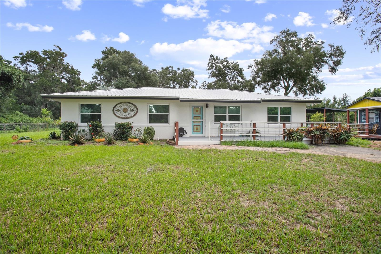 Welcome to your peaceful country escape! This beautifully remodeled 3-bedroom, 2.5-bathroom farmhouse blends classic charm with modern comforts on just under three-quarters of an acre. Step inside to find a warm and open layout, featuring updated finishes throughout and a cozy bonus room/den, and two master suites. The fully fenced yard offers plenty of room to roam, garden, or simply enjoy the outdoors. You'll also find a detached carport with extra storage space, plus a versatile studio complete with working plumbing and a window unit for A/C—great as a guest space, art studio, or workshop. Whether you're entertaining, relaxing, or working from home, this move-in-ready home offers the ideal balance of privacy, comfort, and style. The entire house went under a full rehab in 2021. Some improvements are new AC and handler, updated to gas, all new ZLine and LG appliances, impact windows and tinted, all new electrical throughout, all new drywall and new Barnwood flooring with ceramic and tile in the bathrooms. As an added bonus there is rosemary, 2 Mulberry Trees and 2 Pomegranate Trees. *All info to be verified by buyer(s)*