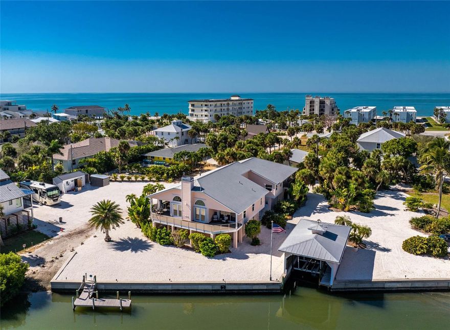 Located on two combined lots totaling .63 acres, this canal front Manasota Key residence delivers a rare level of versatility for those seeking a waterfront lifestyle with ample space for vehicles, boats, and storage. With road access on two sides, a concrete seawall, deeded beach access, and a unique combination of structures—including a covered boathouse with lift, separate wood dock, private boat ramp, and attached RV garage—the property offers a highly functional layout for a variety of uses.

The home’s elevated construction provides added protection and peace of mind for those looking to stay “high and dry.” Additionally, the upstairs level includes storm-rated windows throughout and hurricane shutters on the sliding glass doors for added protection. Upon entering the main living level, the vaulted great room opens to canal views and includes a wood-burning fireplace, kitchen, and sliding doors to a balcony that offers a wonderful vantage point for observing dolphins and manatees in their natural habitat. The primary bedroom is positioned for privacy and includes double walk-in closets, an ensuite bathroom, and its own balcony access.

From the formal dining room, you enter a spacious family room with soaring high ceilings, which includes a wet bar, large storage closet, a projector setup, and a concealed entryway to a private office. Two guest bedrooms, a full guest bath, and a dedicated laundry room complete the main floor.

The lower level of the home provides extensive storage and workspace options. An oversized garage with a 14-ft high door, full bathroom, and workshop can accommodate multiple vehicles and equipment, and includes an existing car lift. A separate two-car under-building garage adds further capacity.

The property features Florida-Friendly Landscaping with crushed shell ground cover and native palms, requiring minimal maintenance. The deep-water canal frontage is ideal for boaters, with a private ramp, an additional dock for fishing or tie-ups, and a boathouse equipped with a 10,000-lb lift. From this location, access to Lemon Bay and the Gulf of Mexico is convenient for boating, fishing, and exploring local waterways.

The combined lots may remain as one large property or be separated to create a buildable homesite that includes the boathouse. Beach access is located directly across Beach Road, providing easy walking access to the shoreline. Discover this exceptional, one-of-a-kind property for yourself—contact us today to arrange your exclusive tour.