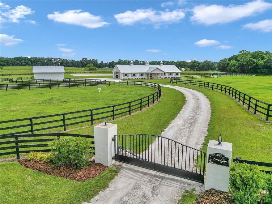 Discover this professionally designed horse property in a premier equestrian neighborhood surrounded by top-level riders from multiple disciplines. This serene and gated 10-acre farm is on a quiet, horse-friendly road with dedicated bridle paths, ideal for hacking out in peace. The property is thoughtfully designed for professional equestrians and passionate amateurs. The 10-stall block barn features spacious 12-by-12-foot matted stalls with windows to the aisle and outside, automatic waterers, fans and a light-filled center aisle with a finished metal ceiling. Inside, enjoy a fully equipped tack room with ample bridle and saddle storage, a laundry room and a half bath. Two under-roof wash/grooming stalls are conveniently just outside the main aisle. The 100-by-200-foot premier custom arena is professionally constructed with high-quality synthetic footing, curb and full irrigation, ideal for high-performance training. A concrete viewing pad allows guests and family to comfortably watch the action. The land is fully perimeter-fenced in four-board fencing, with three-board cross-fencing dividing six large grassy paddocks, all with auto waterers. The charming studio apartment has a cozy feel with a kitchenette, full bath and front porch overlooking the paddocks. The huge two-bay garage provides ample room for parking, storage and equipment. There is an RV hookup and additional covered storage adjoining the garage. This is a unique opportunity to live, train and ride in a special equestrian community.