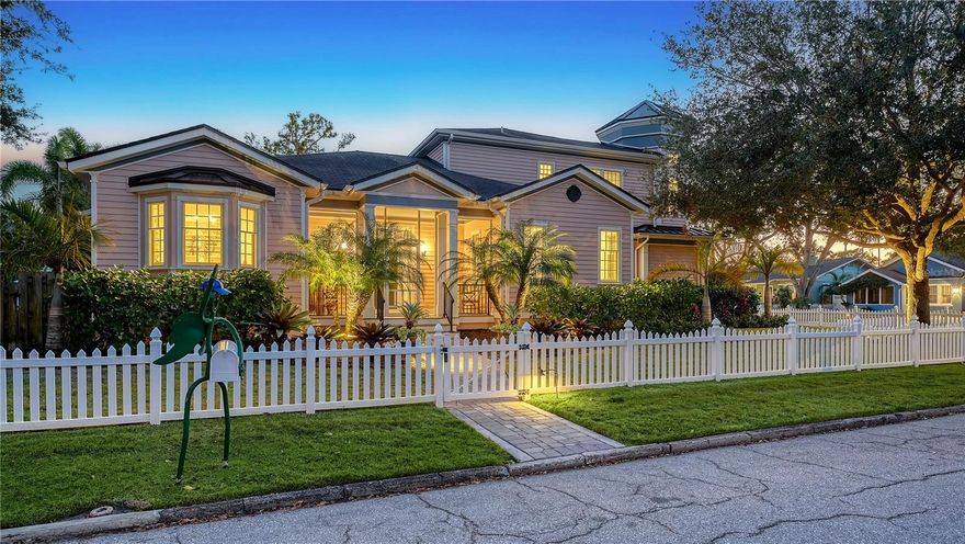 This West of Trail gem is a stunning blend of timeless charm with modern luxury, nestled in one of Sarasota’s most sought-after neighborhoods. Set on an oversized corner lot in the desirable Hudson Bayou community, this custom-designed home, originally built in 2012 and completely renovated by architect John Potvin and luxury home builder Murray Homes in 2019, offers a gracious living experience inside and out. The main residence features three spacious bedrooms, while a detached one-bedroom guest house with an attached one-car garage provides a private retreat for visitors. A charming porch and picturesque white picket fence set the stage for the warm, inviting atmosphere that defines this home. Step inside to discover a beautifully designed interior with natural wood flooring, custom built-ins, and high-end finishes throughout. The heart of the home is the chef’s kitchen, where marble countertops, a large island, top-tier stainless steel appliances, a Wolf gas range, and custom cabinetry create a space as functional as it is stylish. An adjacent breakfast nook and built-in beverage center add to the kitchen’s appeal. The open-concept design seamlessly connects the kitchen to the dining and living areas, making it perfect for entertaining. A stunning curved staircase leads to the private upstairs sanctuary, where the primary suite is a luxurious retreat featuring a sitting room, dual walk-in closets, and his/her spa-inspired bathrooms with a soaking tub, steam shower, and dual dressing areas. The option to create your primary sanctuary on the main level is also available. Additional bedrooms (one bedroom is being used as a library/study) are generously sized, each offering walk-in closets and access to well-appointed bathrooms. The outdoor living spaces are just as impressive. The central courtyard features a heated swimming pool with a sun shelf, waterfall spa, and elegant stone decking. A screened-in patio houses a fully equipped summer kitchen with a gas grill and dining area, ideal for year-round gatherings. A trellis covered lounge area with fire pit provides a cozy setting to unwind, surrounded by lush tropical landscaping for privacy. This residence also includes ample storage and meticulous landscaping that enhances its curb appeal. Located in Hudson Bayou, a family-friendly, downtown neighborhood, this home is positioned in one of Sarasota’s most sought-after school districts. You will love the walkability to the best that Sarasota offers, including the bustling activities of downtown and Sarasota Bayfront, the Main Street farmers market, and cultural attractions. Plus, just a short drive away, you can relish three of Sarasota’s most popular Gulf beaches. Offering the perfect blend of serene living and urban convenience, this remarkable residence is a one-of-a-kind opportunity in the heart of Sarasota.