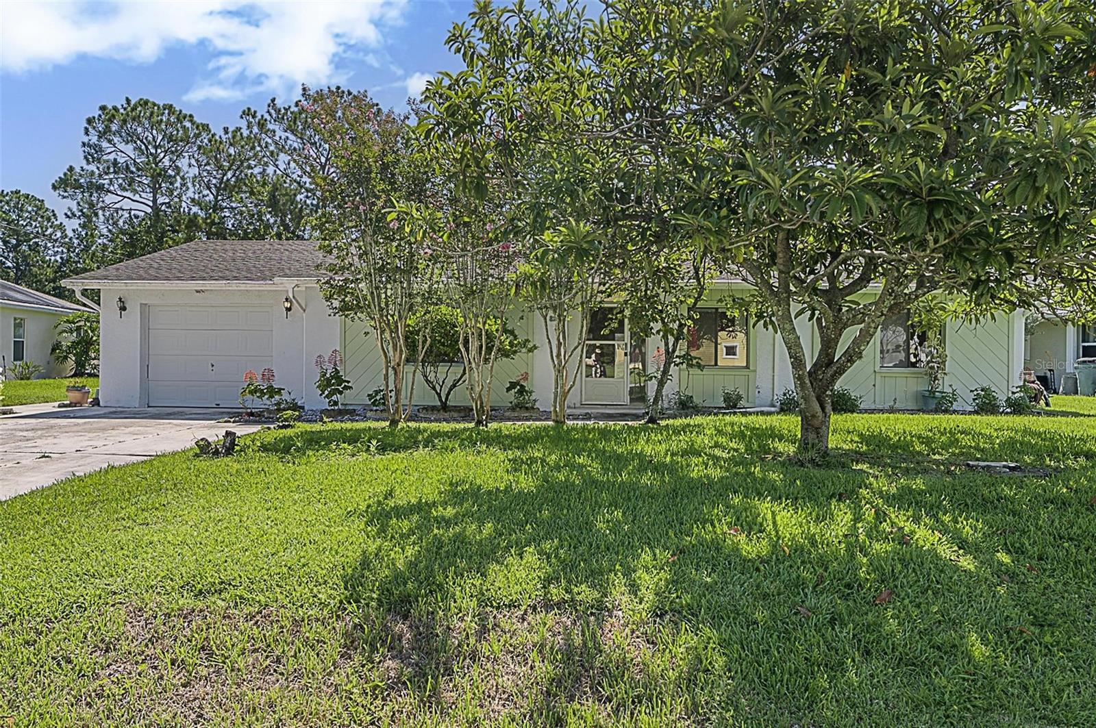 Offered at $250,000, this unique canal front home is full of potential and ready for your personal touch. Unlike a standard layout, this property features an extended living room and an added fourth bedroom, creating extra space for a home office, guest room, or bonus area. The home offers a desirable split floor plan: two guest bedrooms and a full guest bathroom are located on one side, while the spacious primary suite is tucked away off the kitchen for added privacy. The primary bedroom includes a walk-in closet and direct access to a full bath. There are two doors leading outside: one from the kitchen to a large covered lanai and another from the extended living area to the backyard and freshwater canal. Enjoy outdoor living with a partial fence for pets, a walkway, and your own private dock. Additional highlights include tile flooring throughout, a brand-new A/C (2025), a three year old water heater, and an original 1992 roof. The one car garage is paired with an extended driveway for extra parking. Priced to sell and best suited for cash or conventional buyers, this one of a kind home is your chance to own a waterfront property with room to grow!